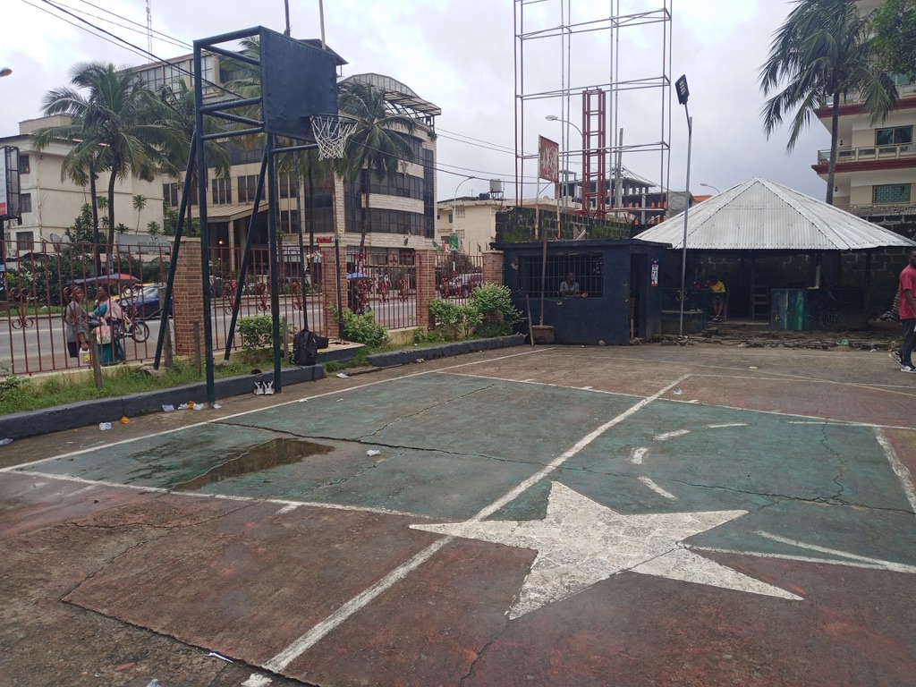 Two white stars painted on a basketball court in the compound of St Peter's Church in Monrovia, Liberia indicate where victims of the first Liberian war have been buried [Courtesy of Robtel Pailey]