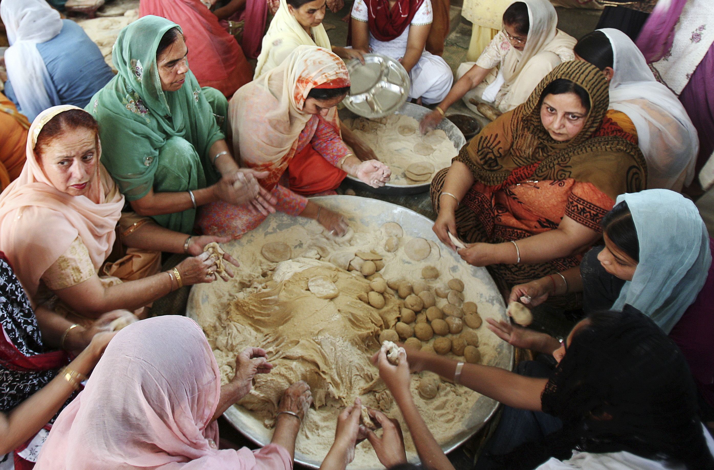Devotees make chapattis (bread) at a community kitchen in a Gurdwara (Sikh temple) on Baisakhi festival in the northern India city of Chandigarh