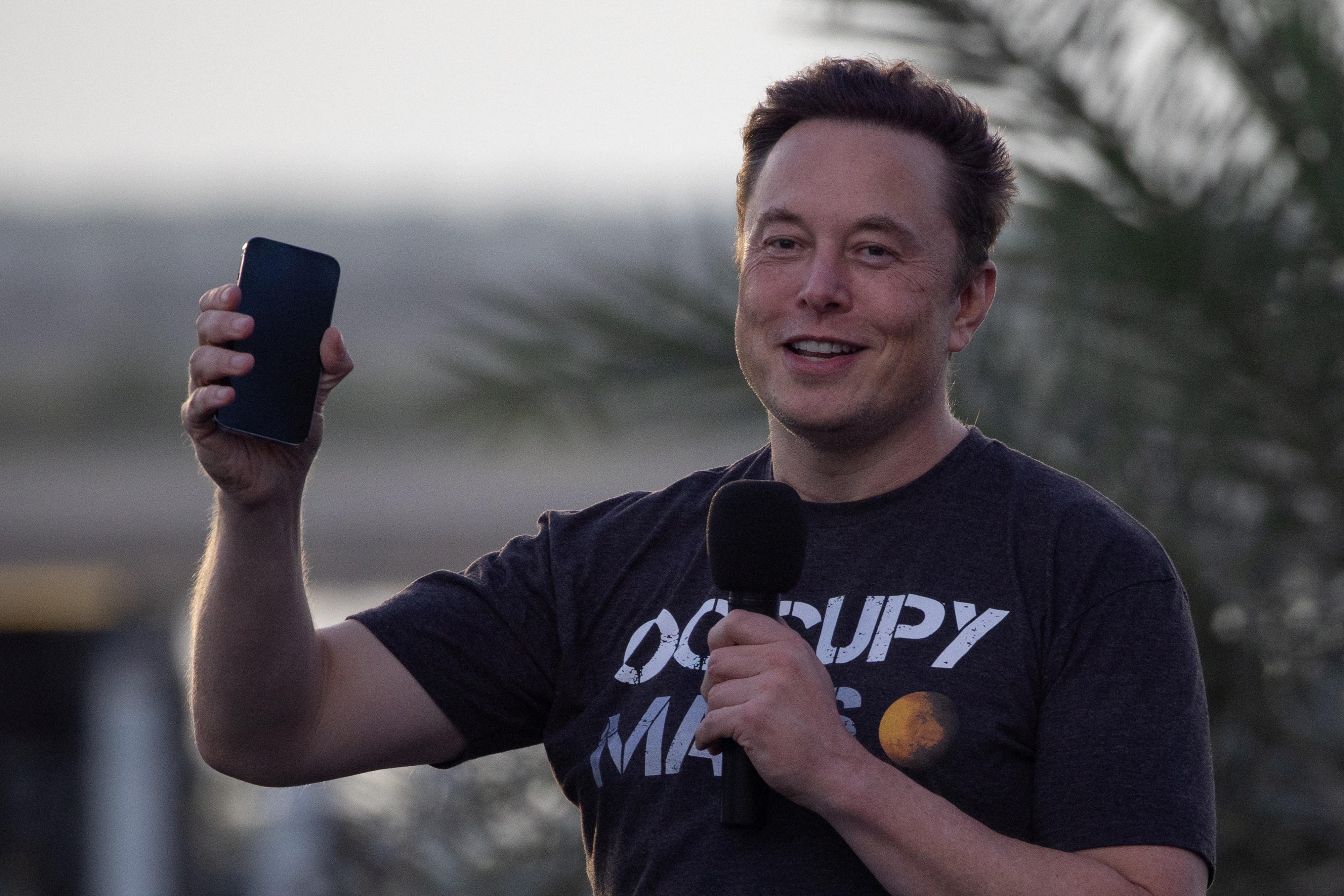 Elon Musk holding a phone