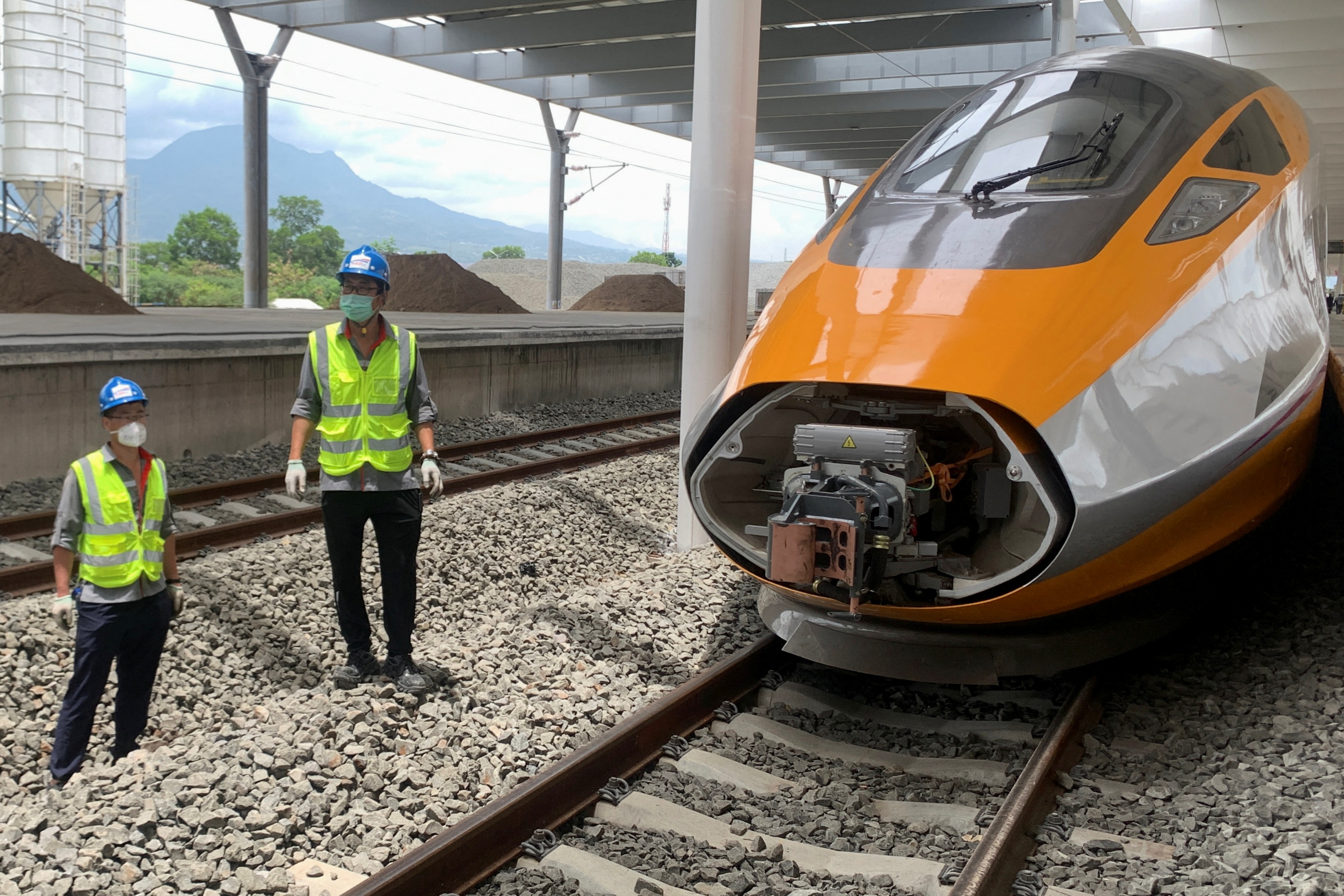 Workers stand beside an Electric Multiple Unit high-speed train for a rail link project part of China's Belt and Road Initiative, at Tegalluar train depot in Bandung, West Java province, Indonesia [File: Yuddy Cahya Budiman/Reuters]