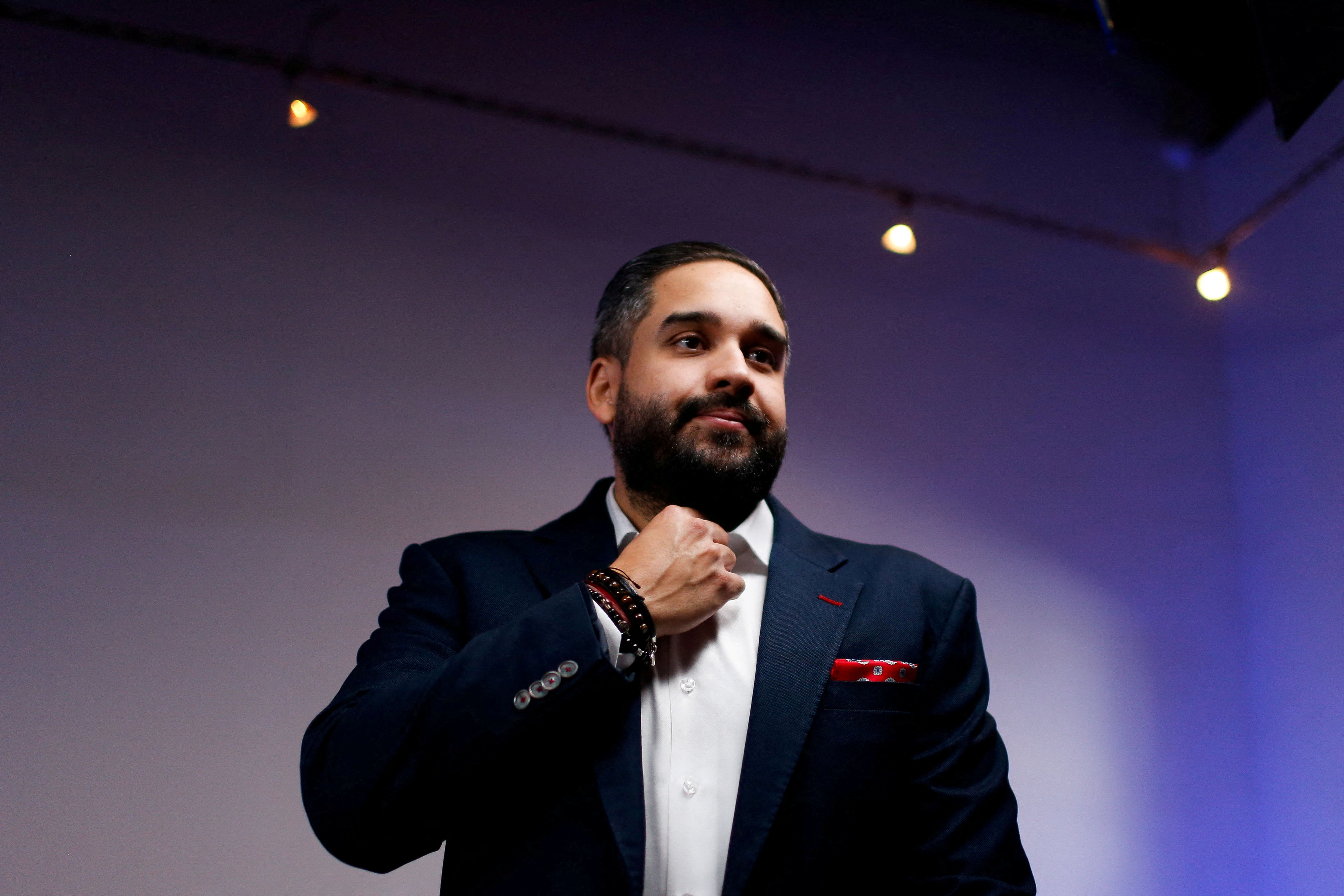 Nicolas Maduro Guerra, member of Venezuela's National Assembly and son of Venezuela's President Nicolas Maduro, attends an interview with Reuters, in Caracas, Venezuela December 8, 2022. He wears a dark suit and white shirt and stands in front of a blank blue backdrop.