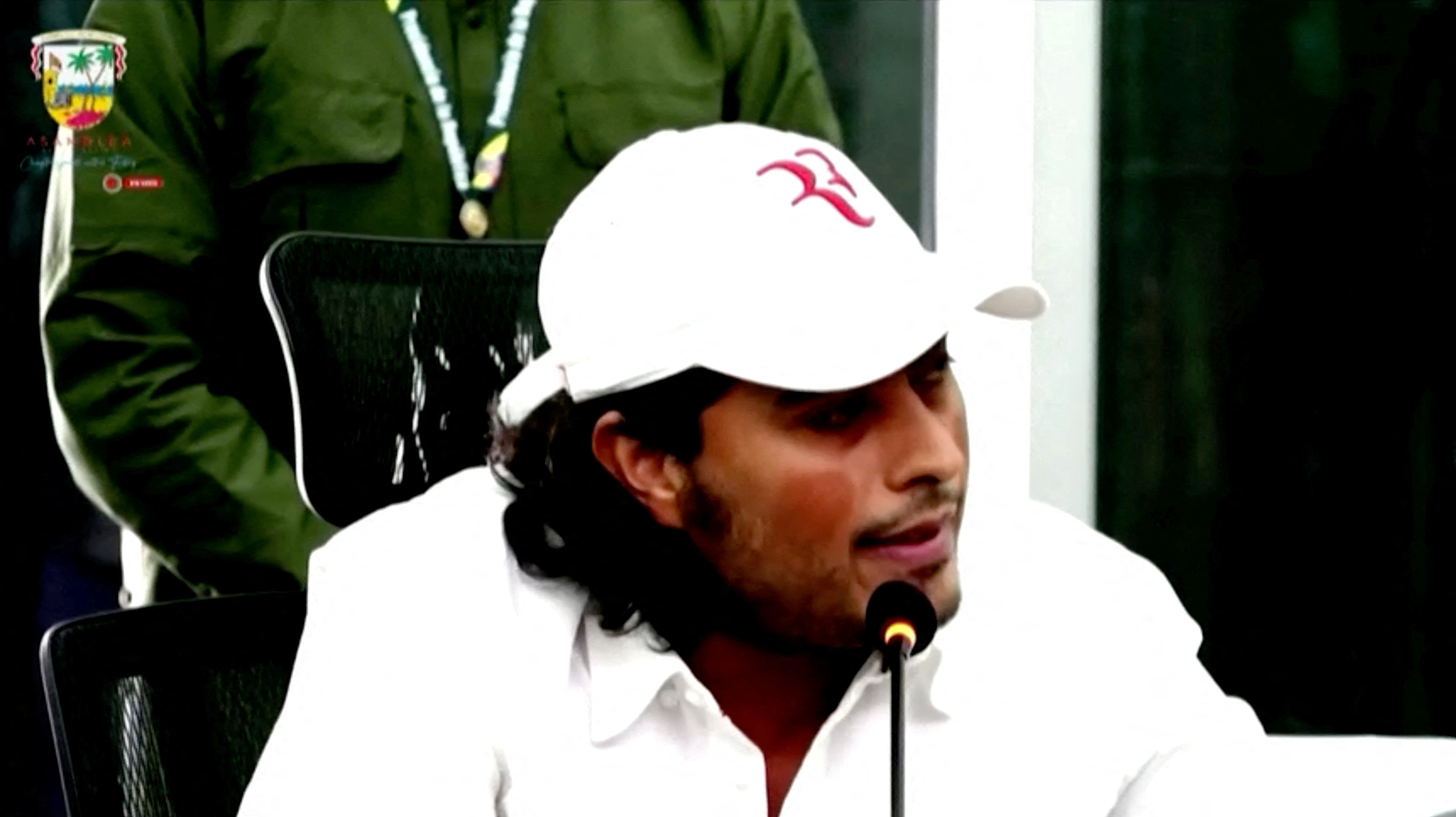 Nicolas Petro, son of Colombian President Gustavo Petro, speaks at the Atlantic Assembly in Barranquilla, Colombia on March 14, 2023, in this screengrab taken from a handout video. He wears a white baseball cap and a white shirt and speaks into a microphone.