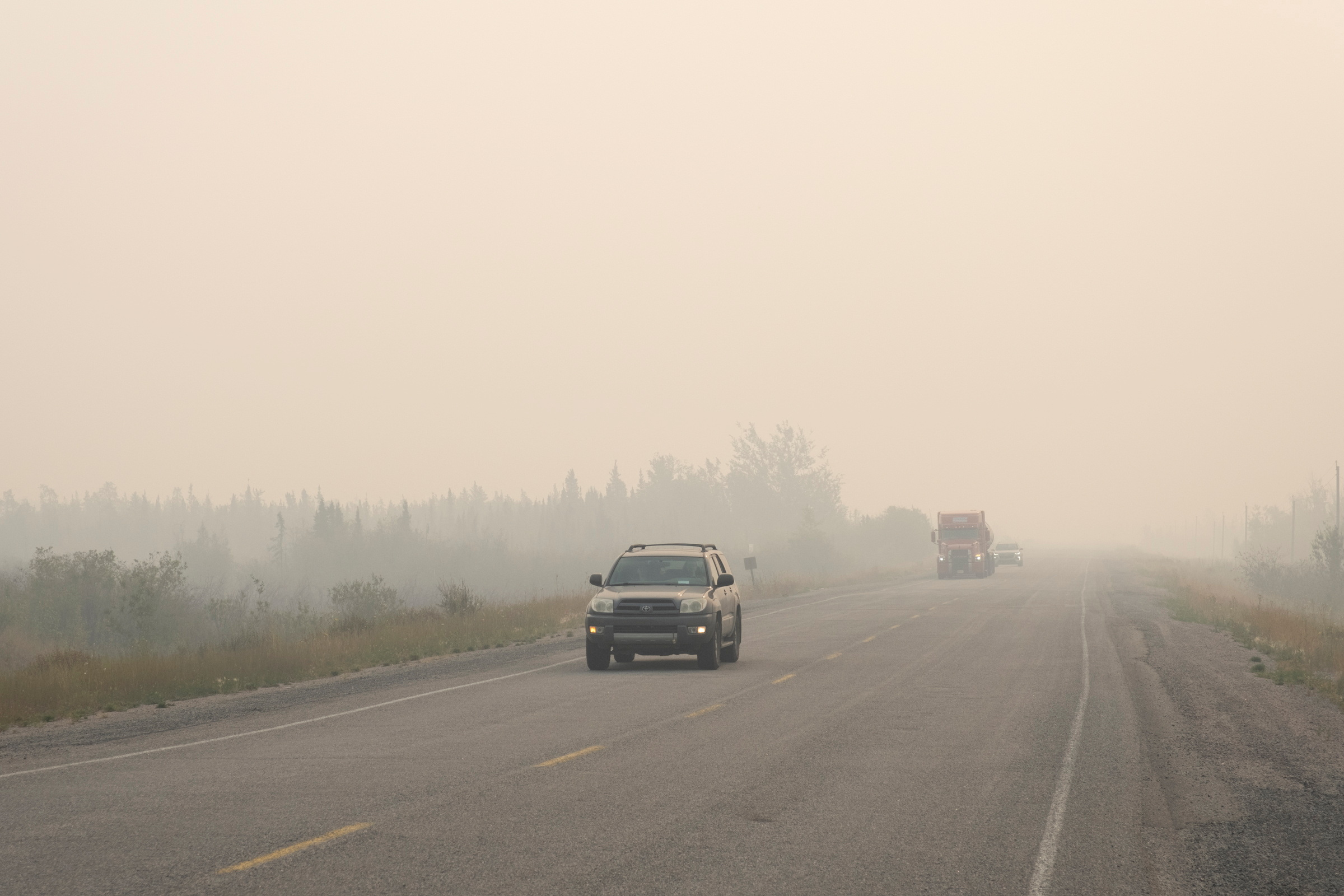 Vehicles leave Yellowknife as a wildfire approaches
