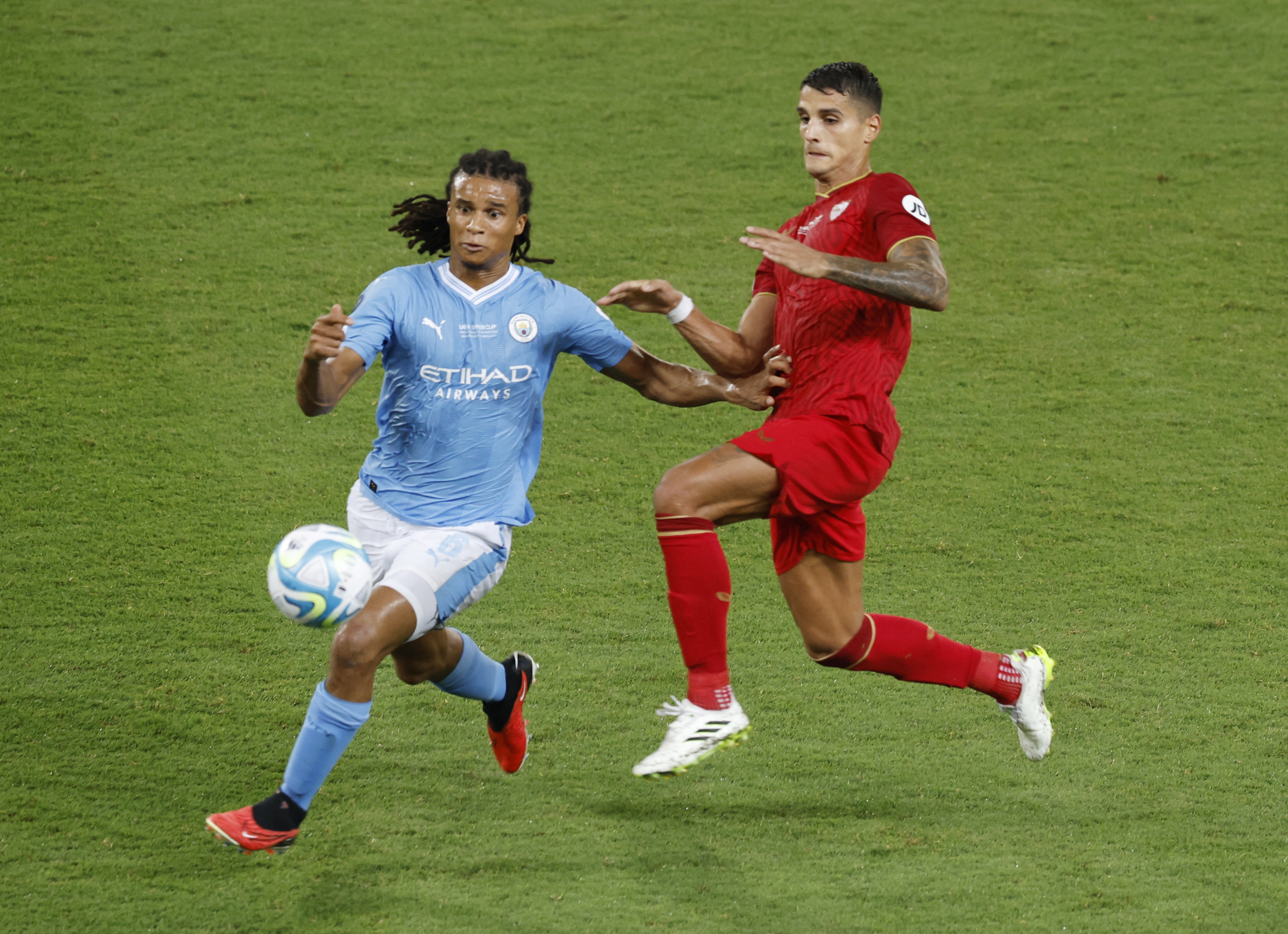 Soccer Football - UEFA Super Cup - Manchester City v Sevilla - Georgios Karaiskakis Stadium, Athens, Greece - August 16, 2023 Manchester City's Nathan Ake in action with Sevilla's Erik Lamela REUTERS/Louiza Vradi