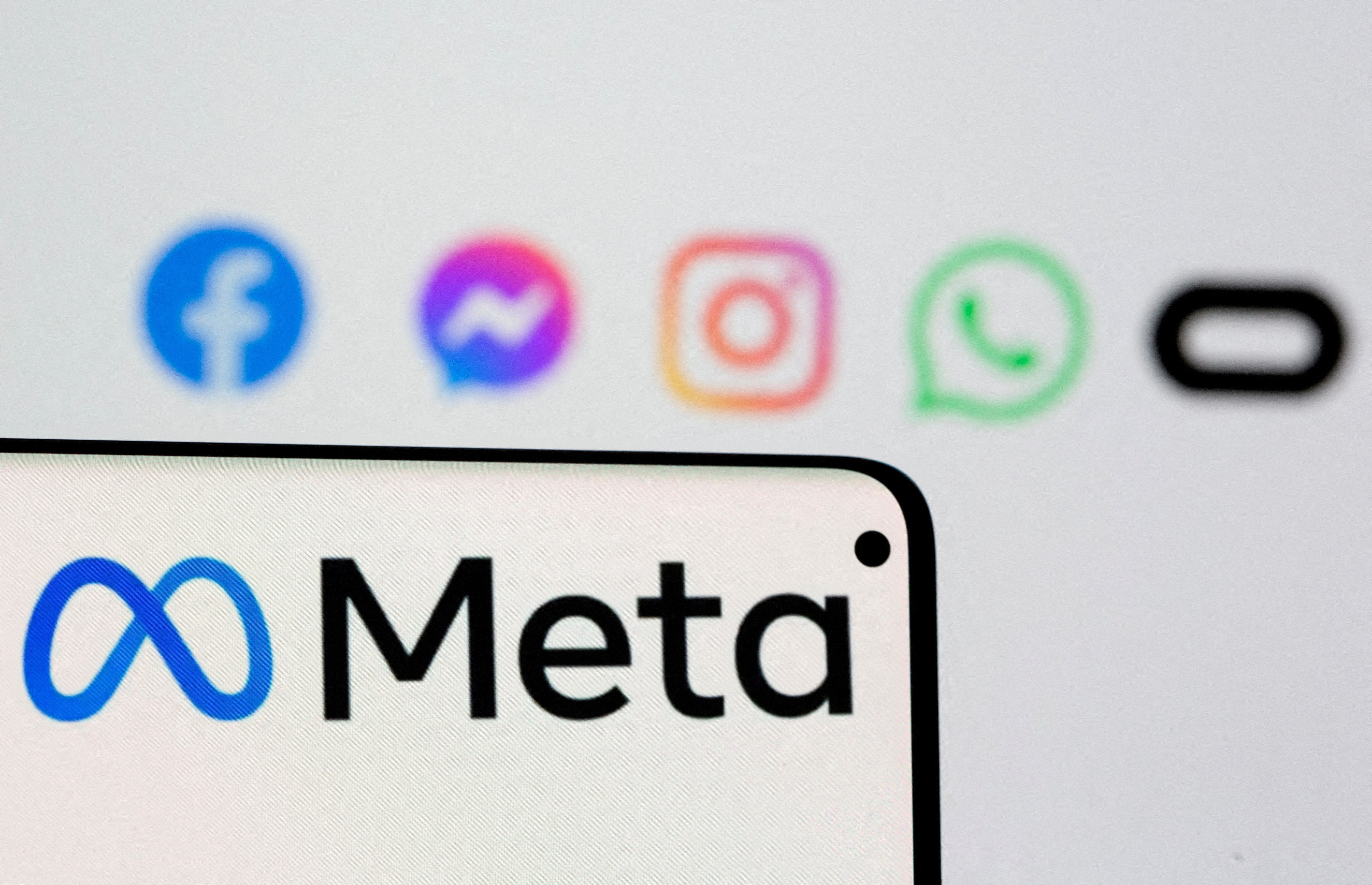 Facebook's new rebrand logo Meta is seen on smartphone in front of displayed logo of Facebook, Messenger, Instagram, Whatsapp and Oculus in this illustration picture taken October 28, 2021.