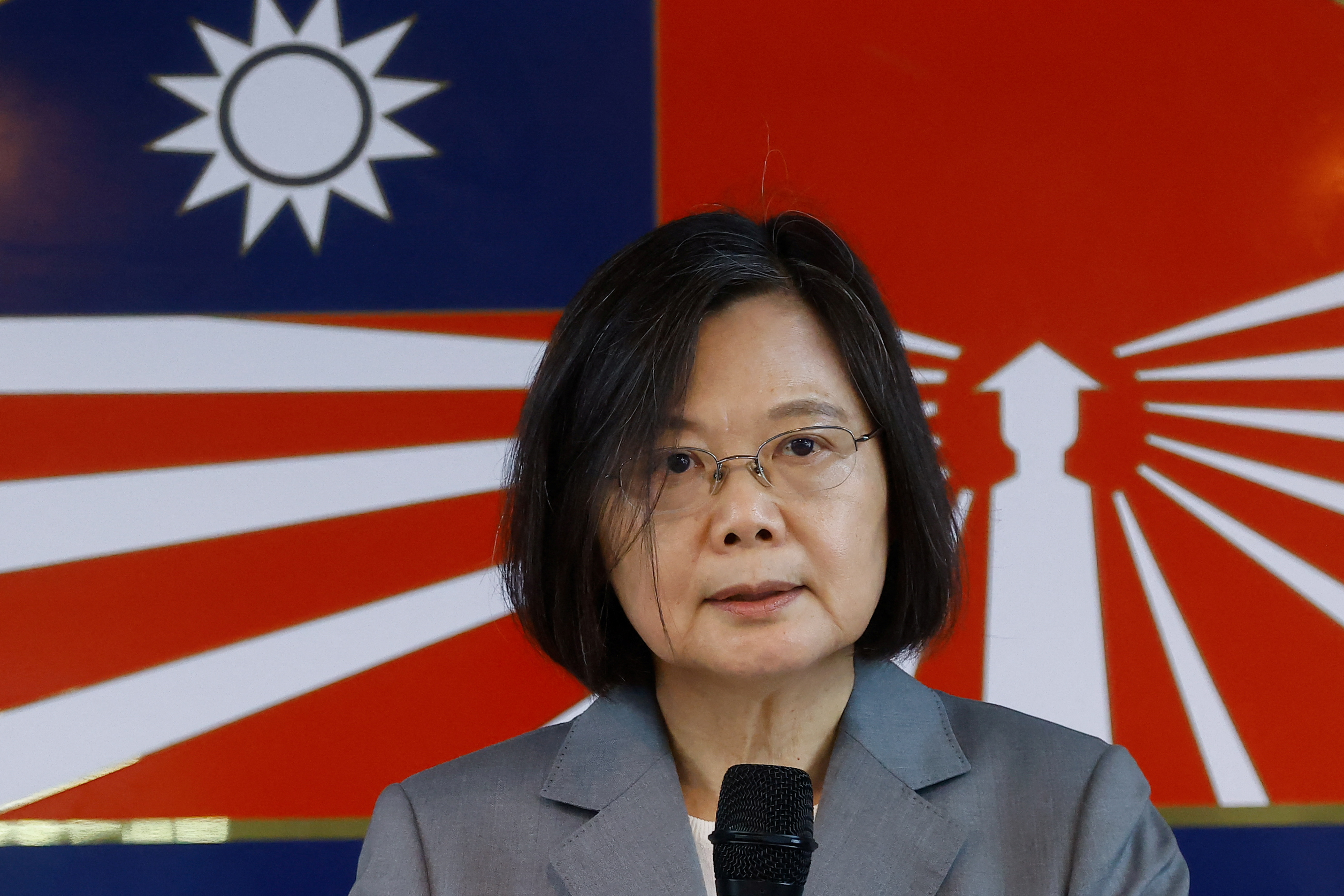 Standing in front of a flag, Tsai Ing-Wen speaks into a microphone to mark the 65th anniversary of the Second Taiwan Straight Crisis.