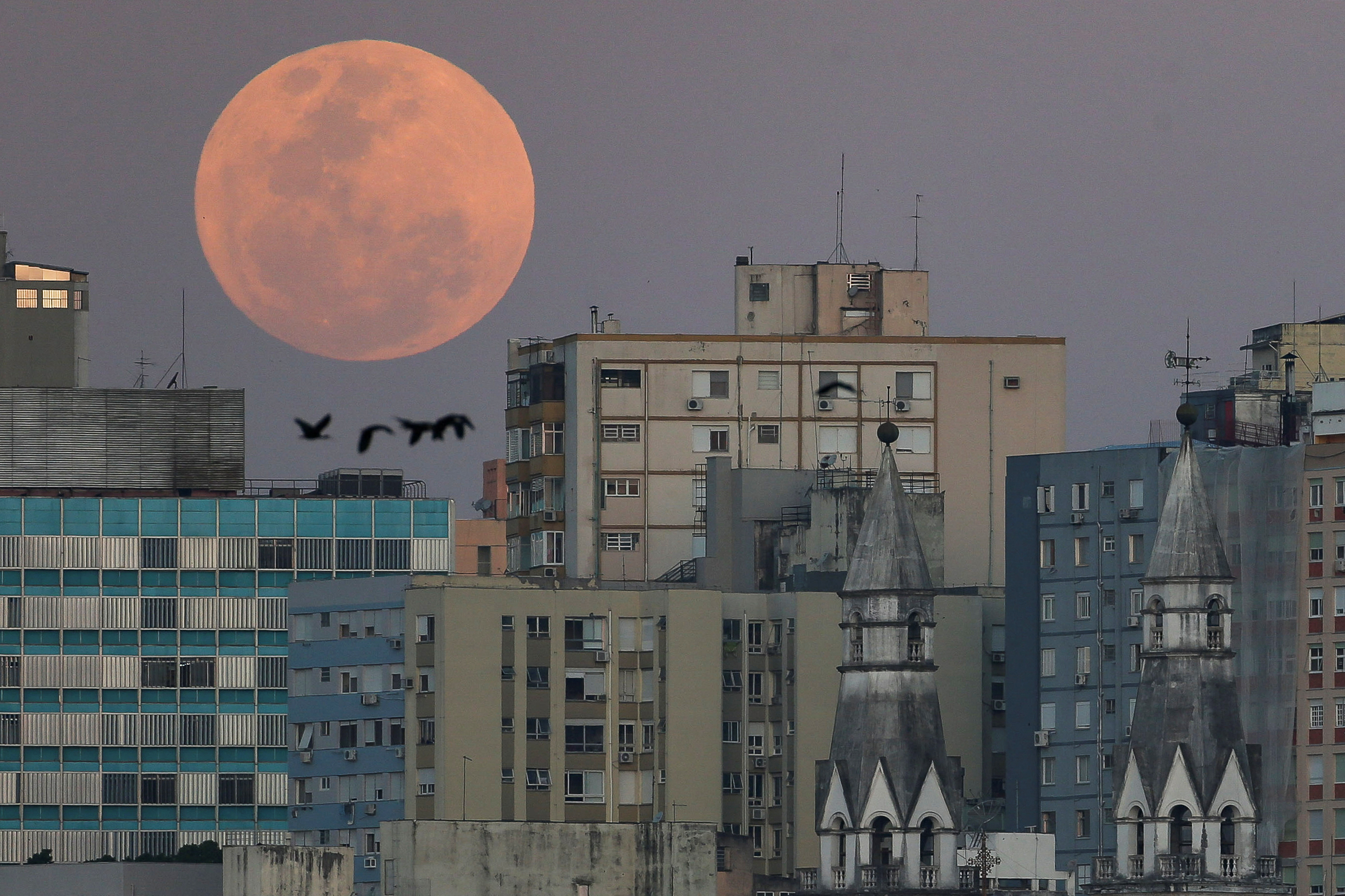 A view shows a full moon known as the 'Blue Moon' over de city of Porto Alegres, Rio Grande