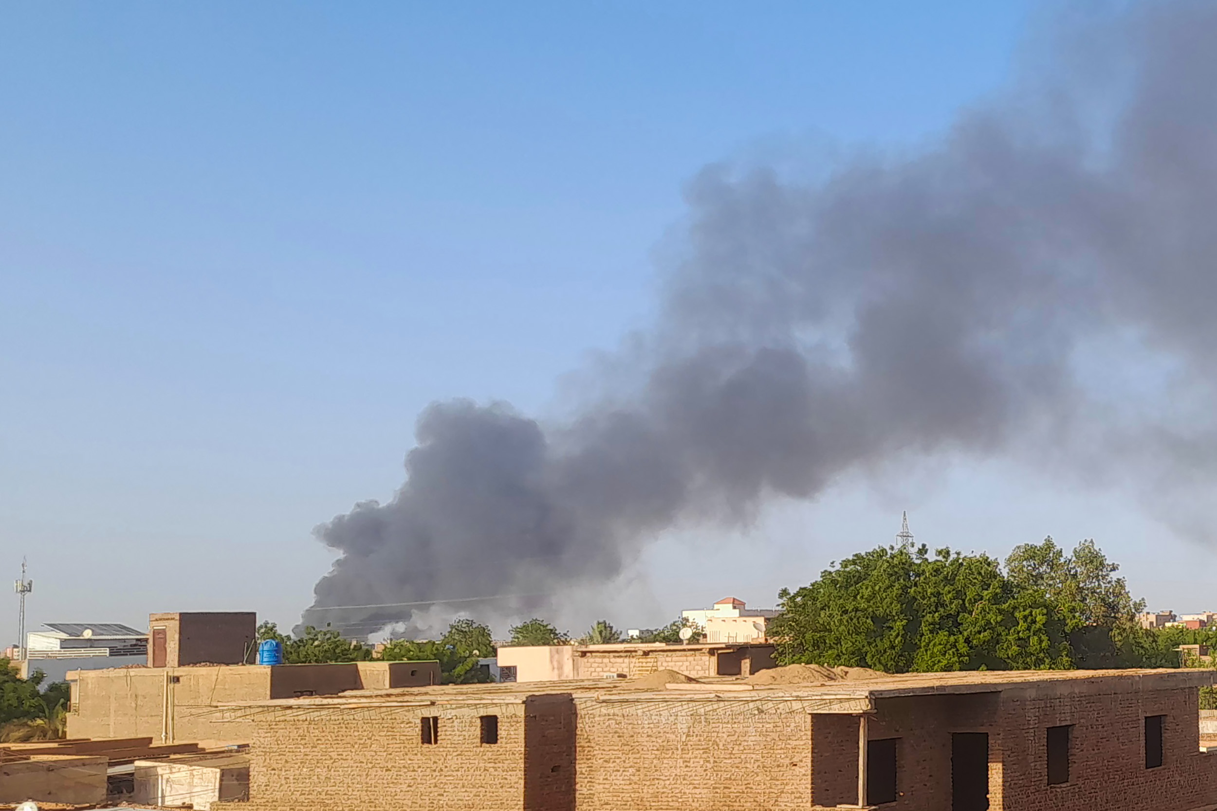 Smoke billows in the distance around the Khartoum Bahri district amid ongoing fighting on July 14, 2023. - War-torn Sudan's capital experienced a communications blackout for several hours on July 14, residents said, as the army and paramilitary forces waged intense battles across Khartoum and humanitarian groups warned of worsening crises.