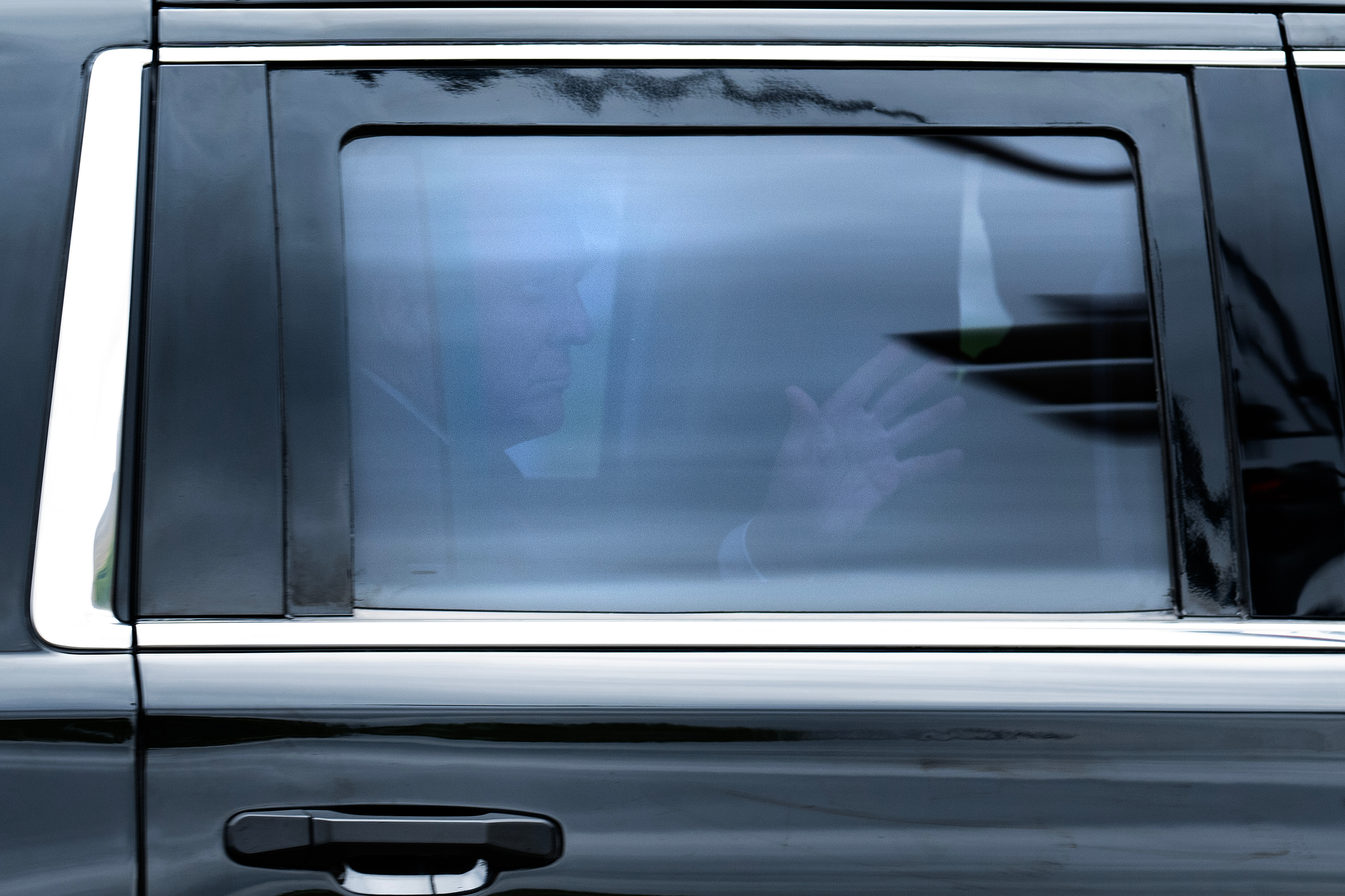 Former President Donald Trump waves from an SUV on his way to federal court in Washington, DC