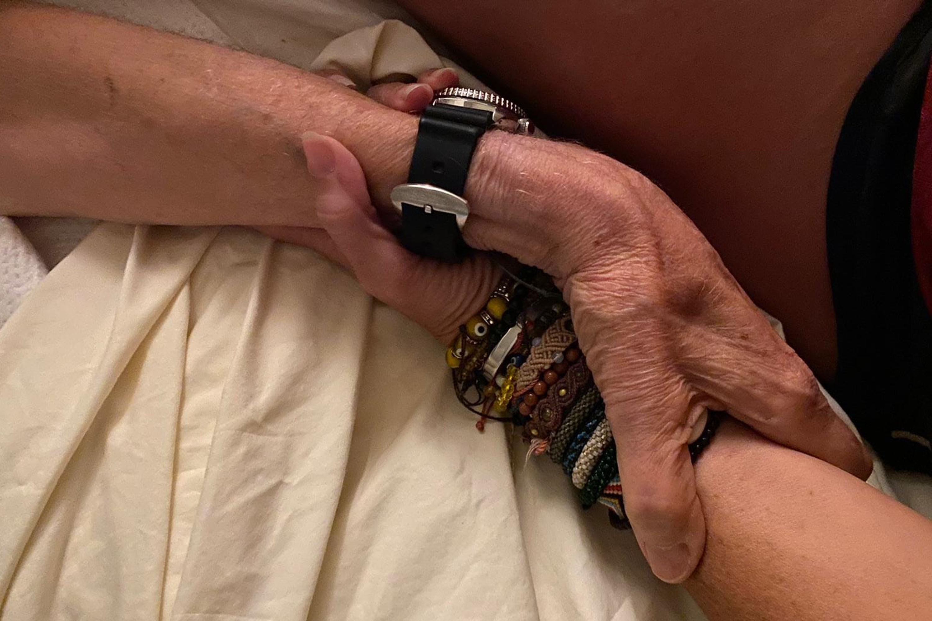 The author holding the hand of her dying father