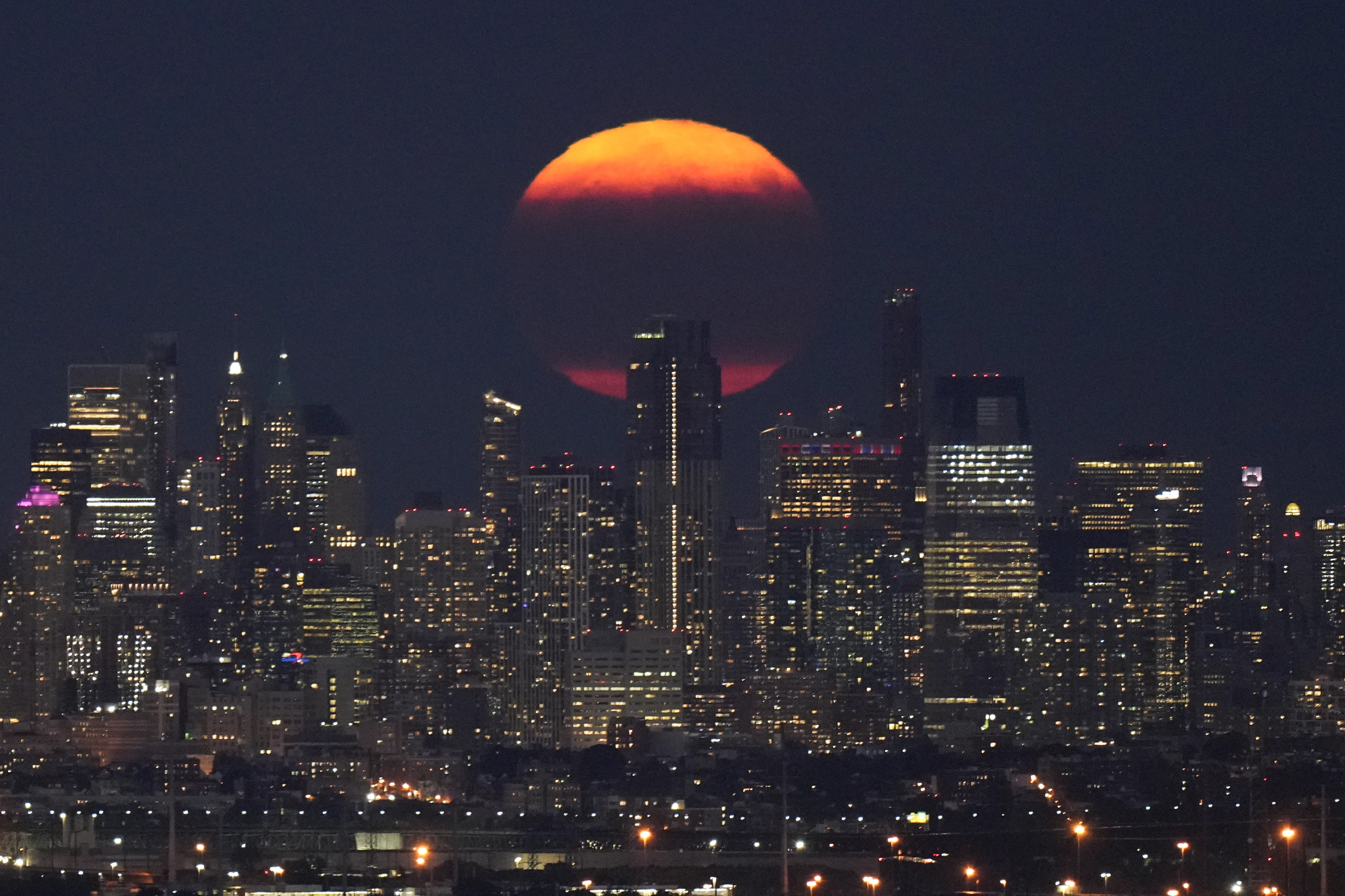 The moon rises through clouds over the skyline of lower Manhattan as seen from West Orange, N.J., Tuesday, Aug. 1, 2023. The first of two supermoons in August graced the skies on Tuesday. A supermoon is broadly defined as a full moon that is closer to the Earth than normal. That makes it appear slightly brighter and bigger in the sky. (AP Photo/Seth Wenig)