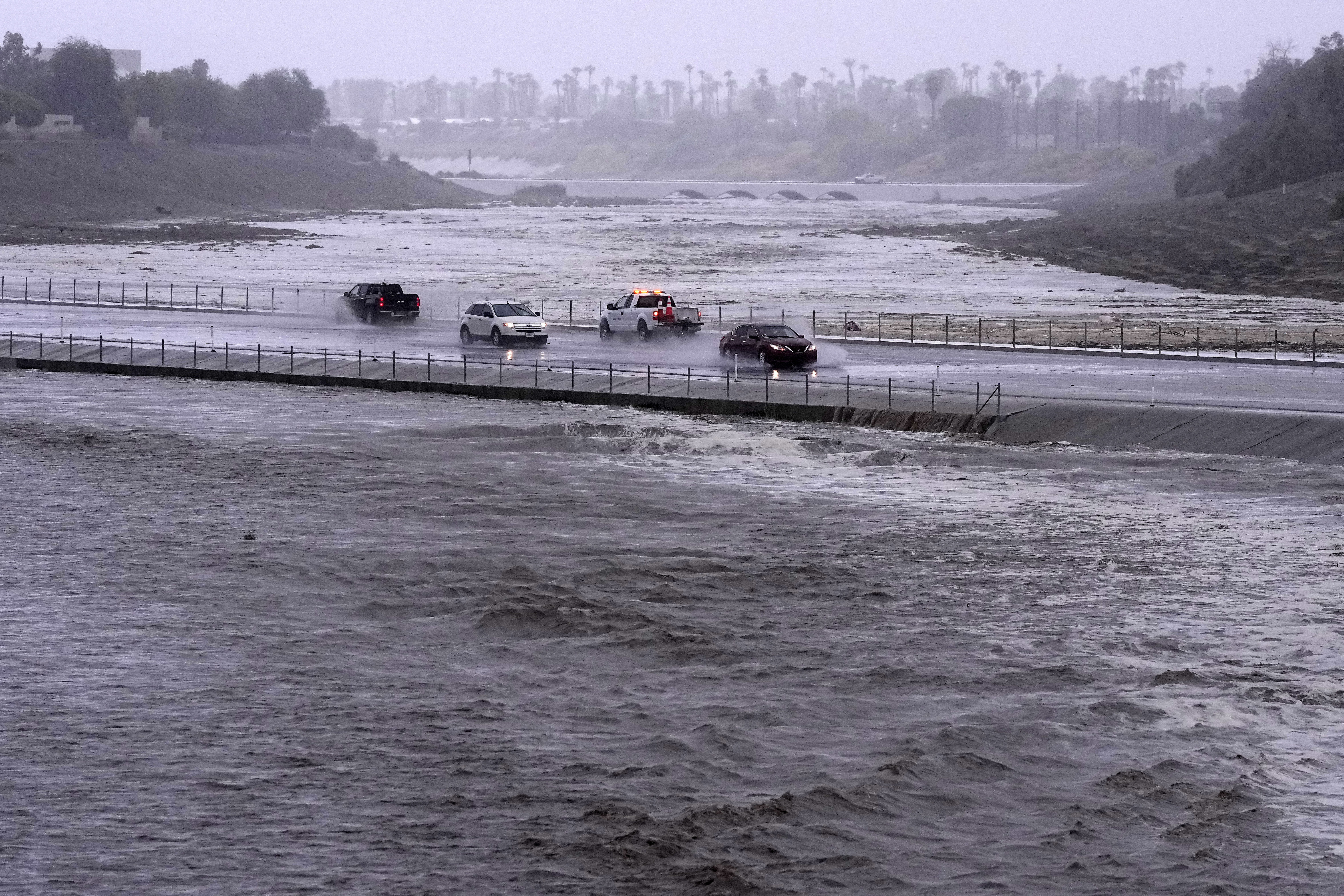 Vehicles cross over a flood control basin.