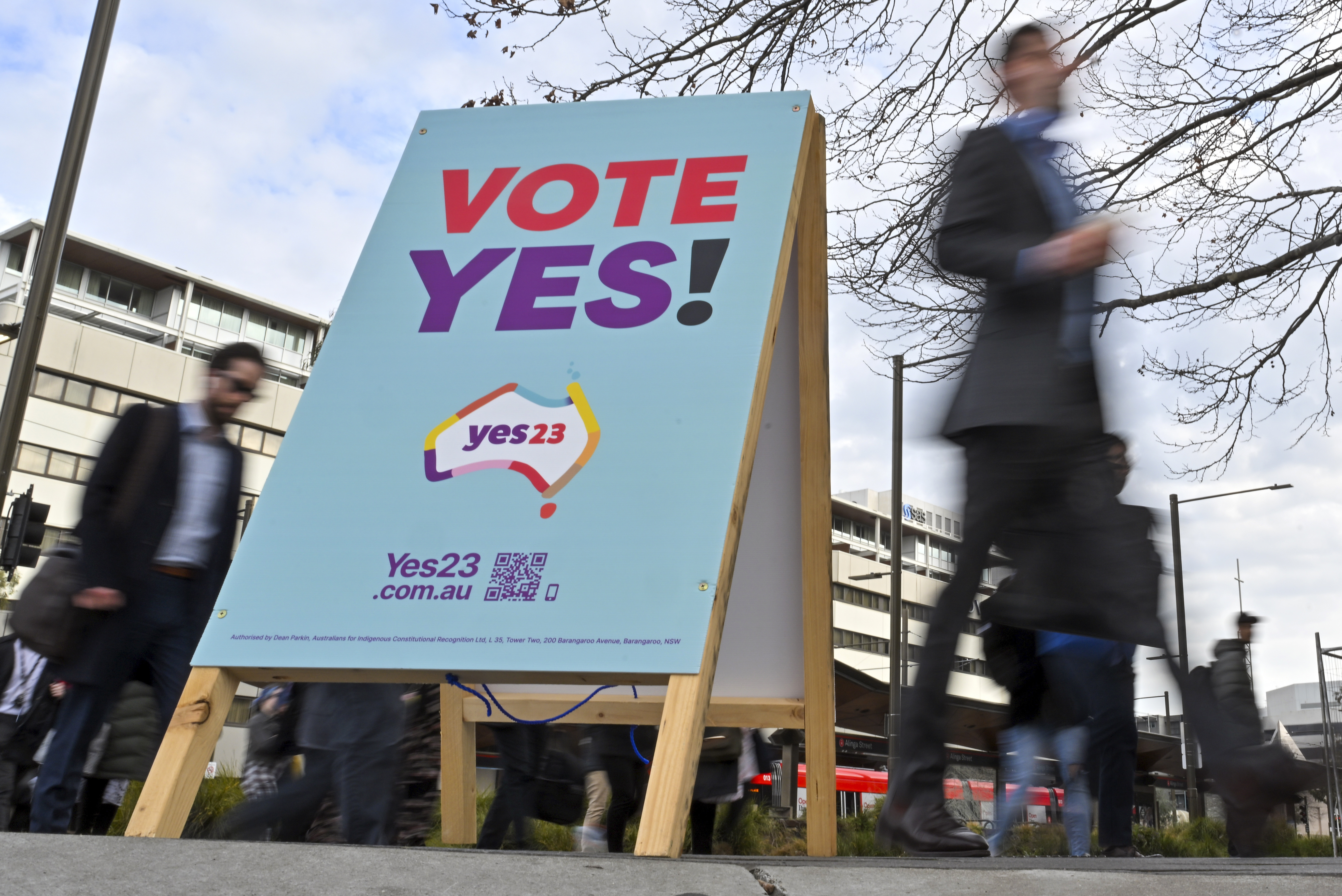 A stand urging a 'yes' vote placed on the street in Canberra. People are walking past.