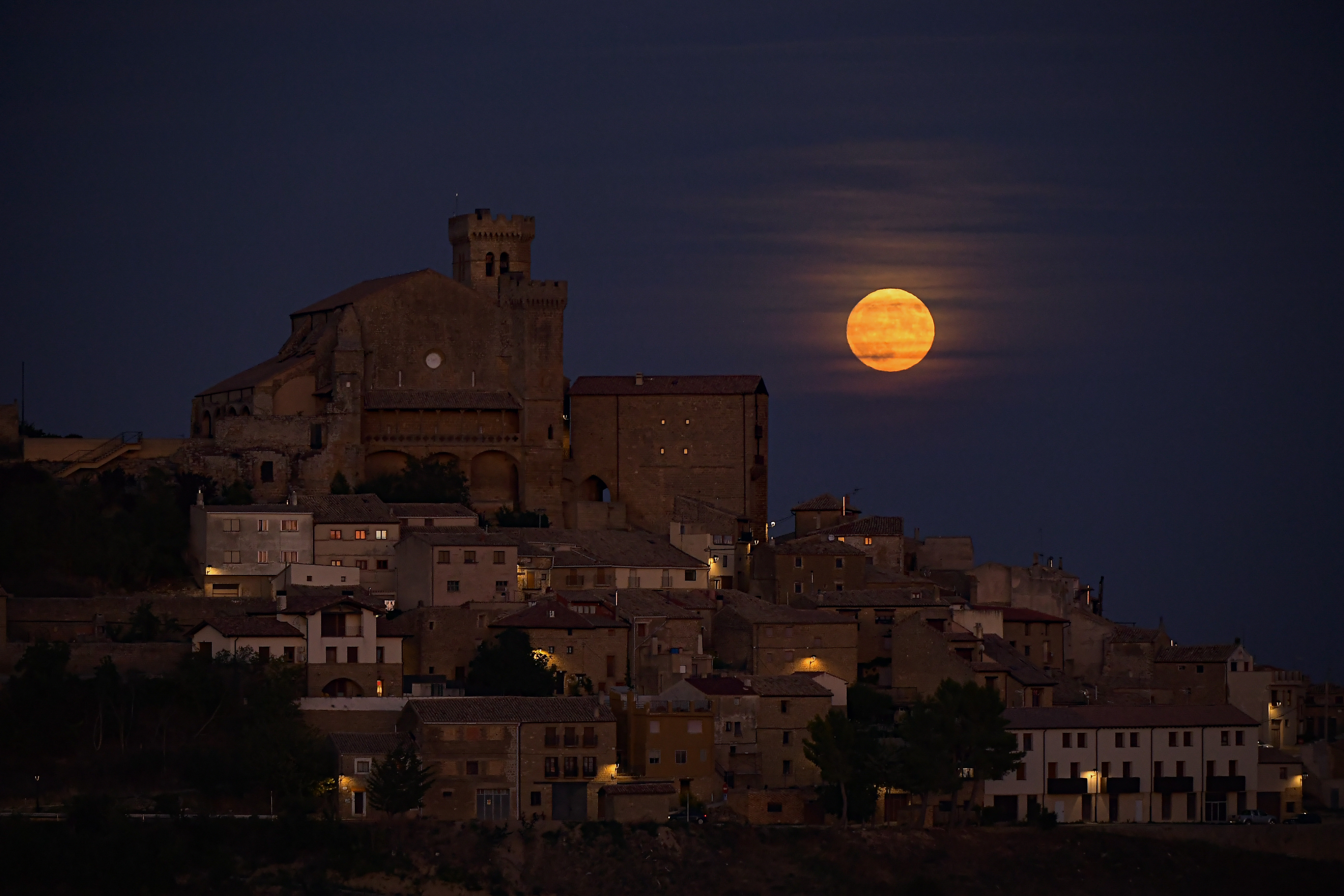 The moon known as blue moon rises behind the small village of Spain