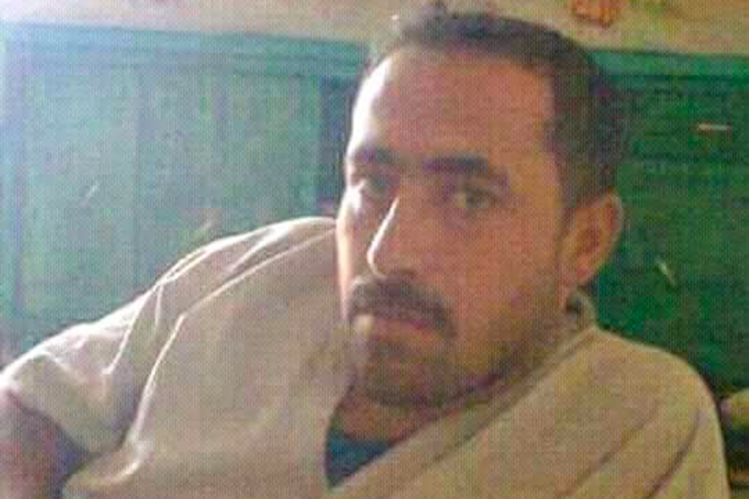 Mustafa leans on one elbow and looks at the camera in a grainy mobile phone photo