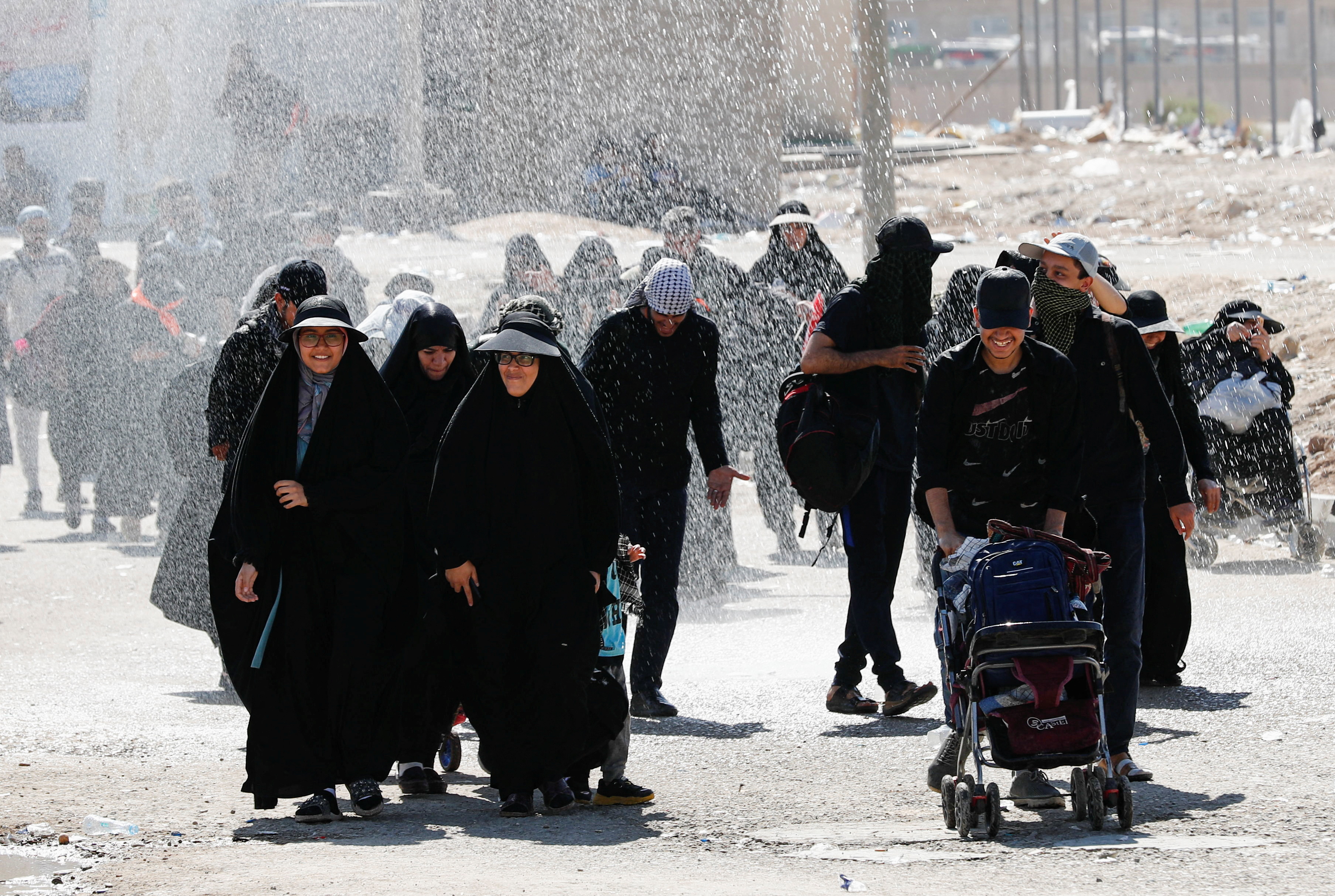 Iranian Shi'ite pilgrims walk on a road after entering Iraq through the Zurbatia border crossing between Iran and Iraq, as they head towards Iraq's holy city of Kerbala to attend the holy Shi'ite ritual of Arbaeen, in Zurbatia, Iraq