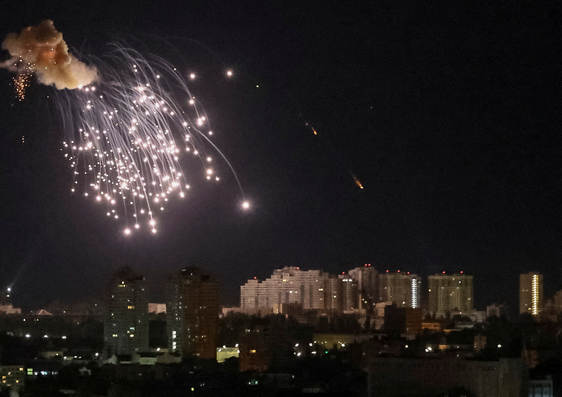 An explosion of a drone is seen in the sky over the city during a Russian drone strike in Kyiv.