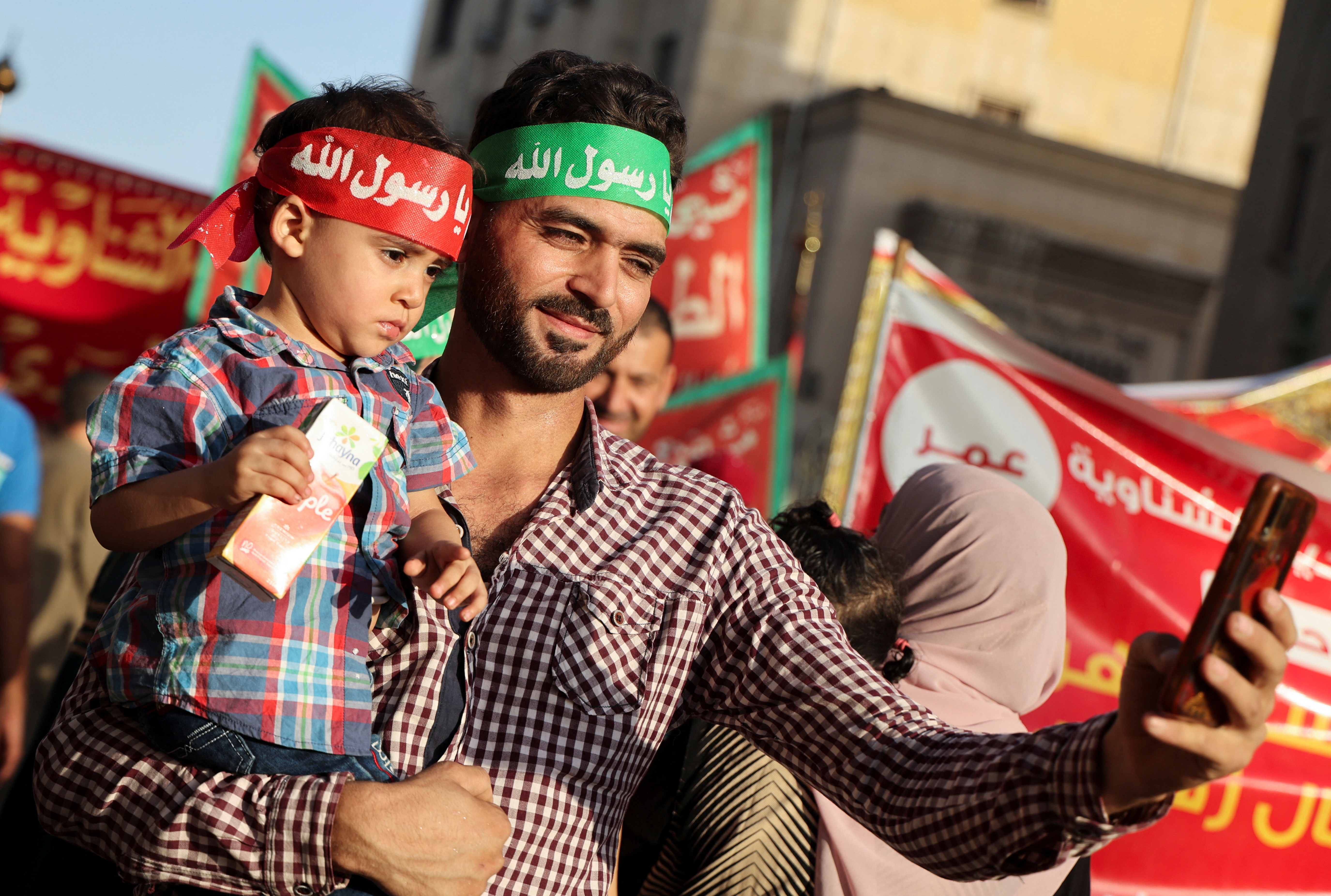 A Sufi Muslim wearing a headband reading "Prophet my love", holds his son, as they celebrate "Mawlid al-Nabawi", or the birth of Prophet Mohammad, in Al Azhar district, Old Cairo, Egypt, September 27, 2023. REUTERS/Amr Abdallah Dalsh