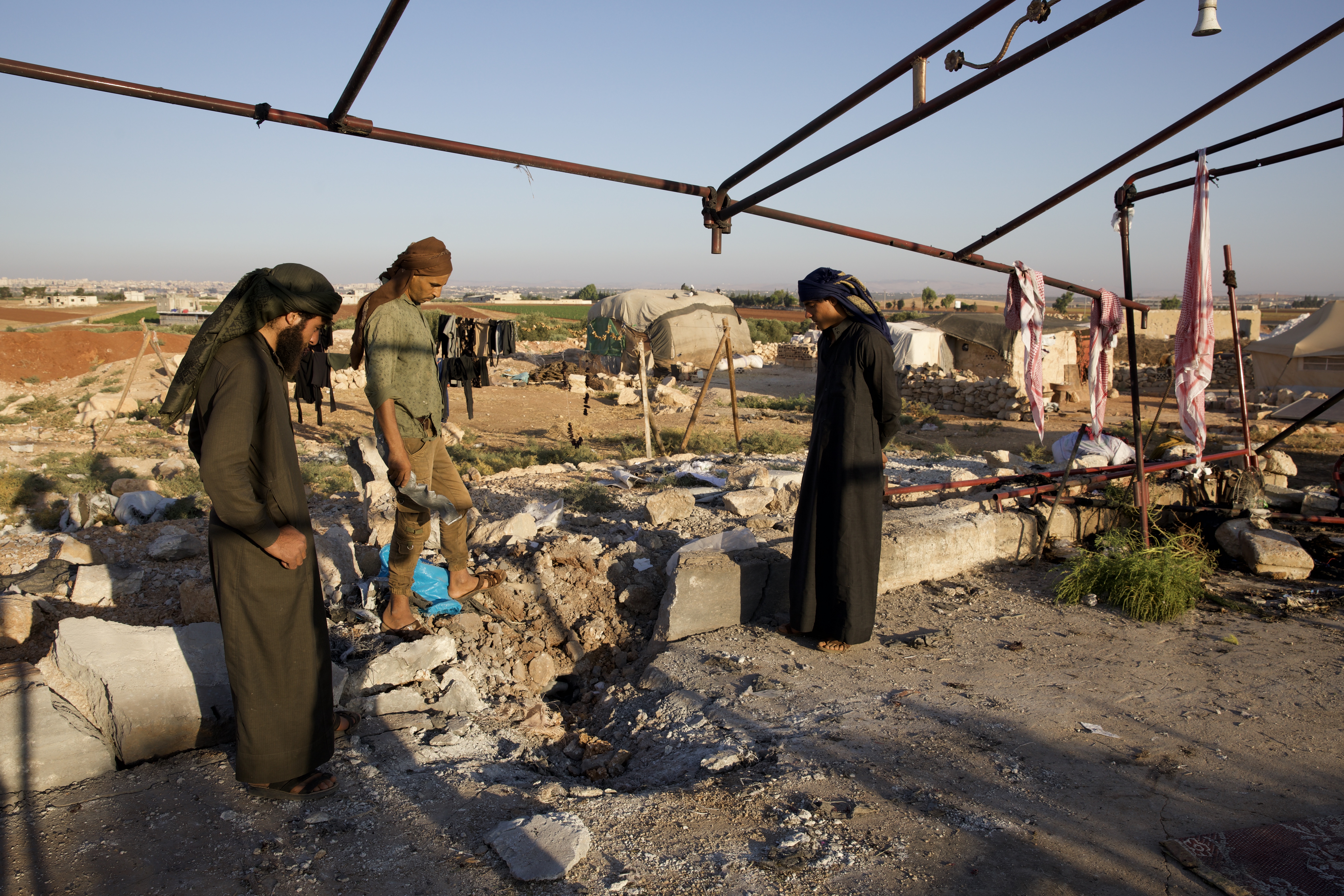 Residents inspect damage to a displacement camp tent, which was shelled by Syrian regime forces on 23 September 2023.