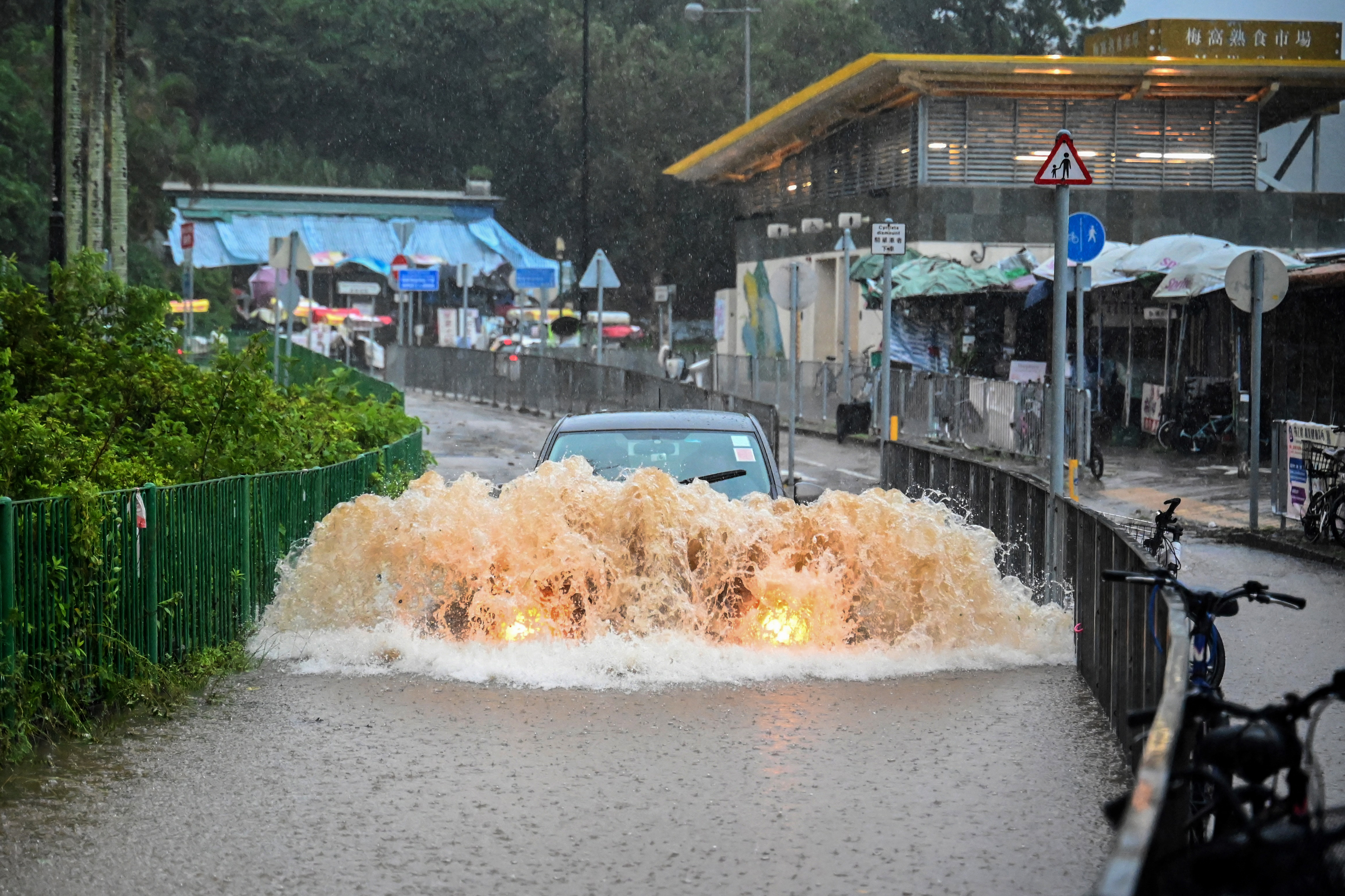 A motorist drives through floodwaters on Lantau Island