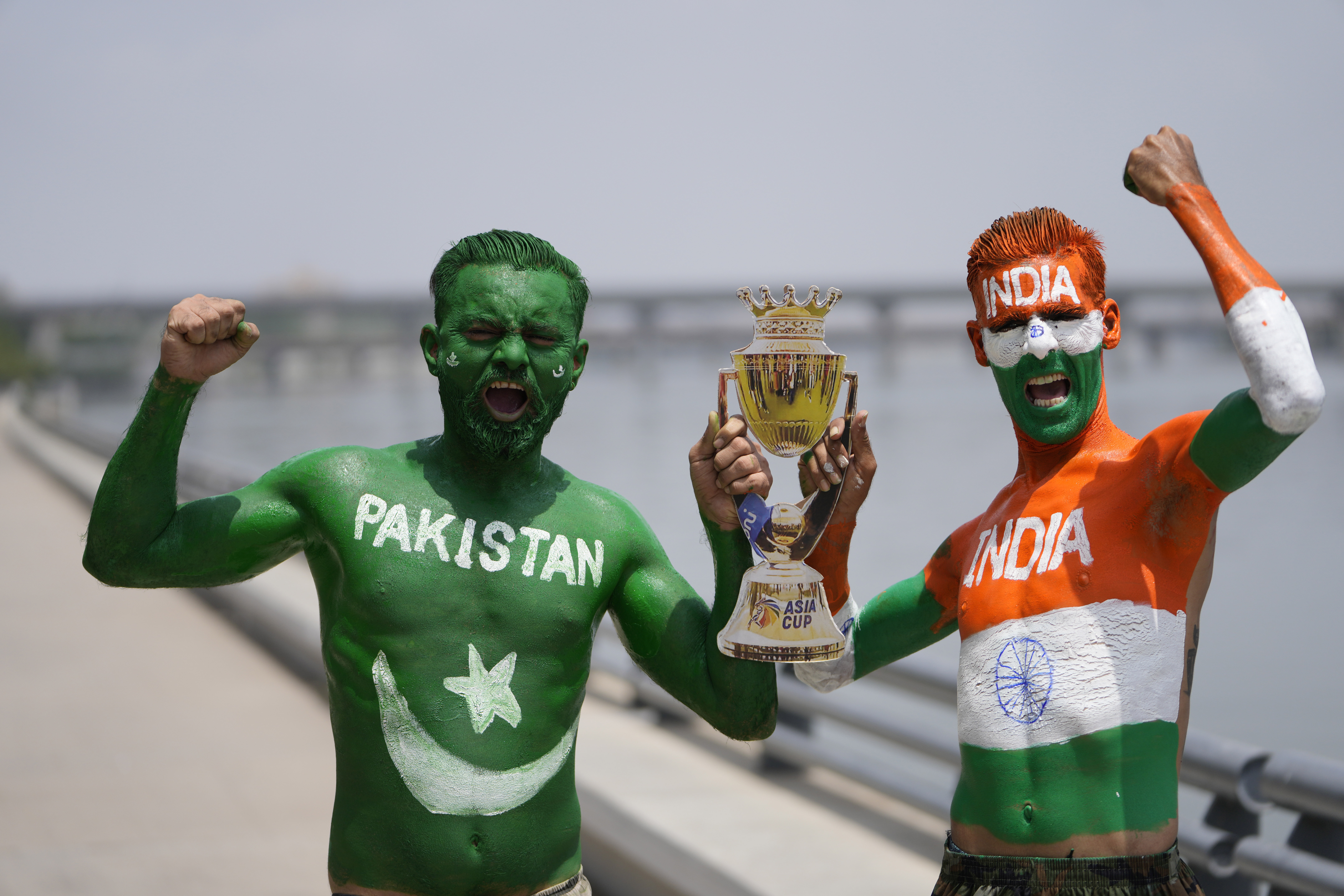 Indian cricket fans, their bodies painted in the colors of the national flags of India and Pakistan, pose for photographs in Ahmedabad, India, Friday, Sept. 1, 2023. India and Pakistan will play an Asia Cup cricket match in Sri Lanka on Saturday. (AP Photo/Ajit Solanki)