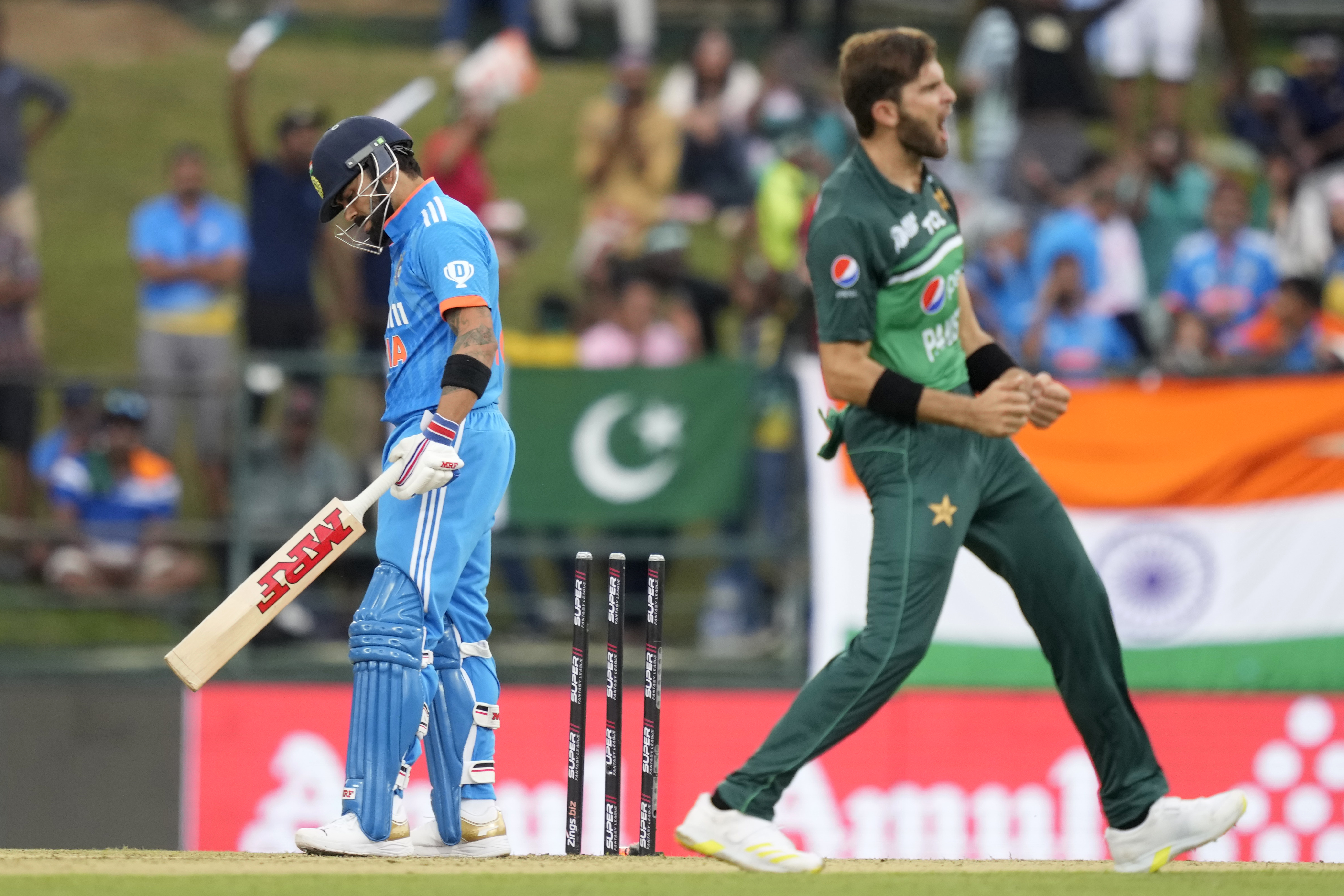 India's Virat Kohli, left, looks down after being bowled out by Pakistan's Shaheen Shah Afrid