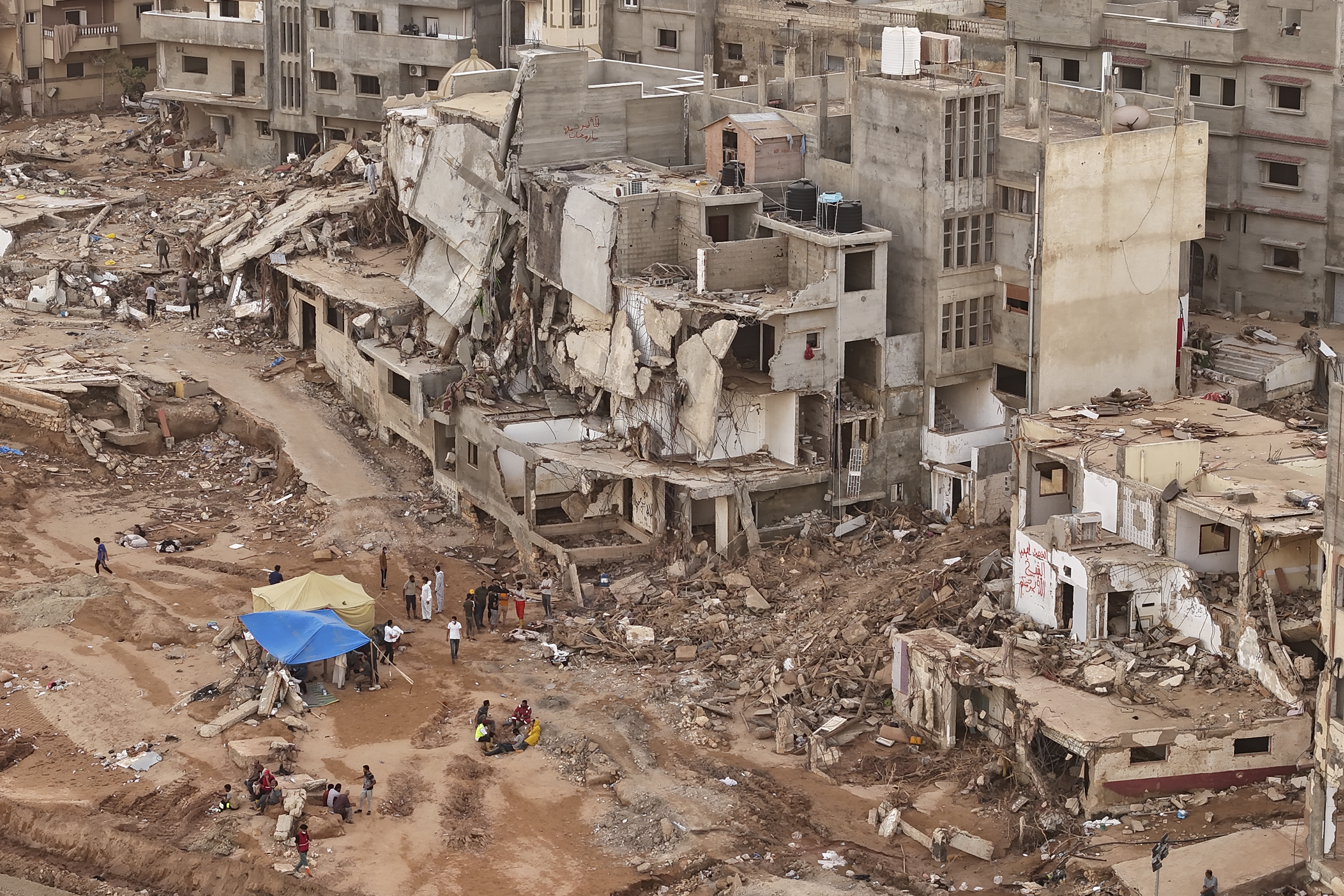 Rescuers and relatives of victims set up tents in front of collapsed buildings in Derna, Libya