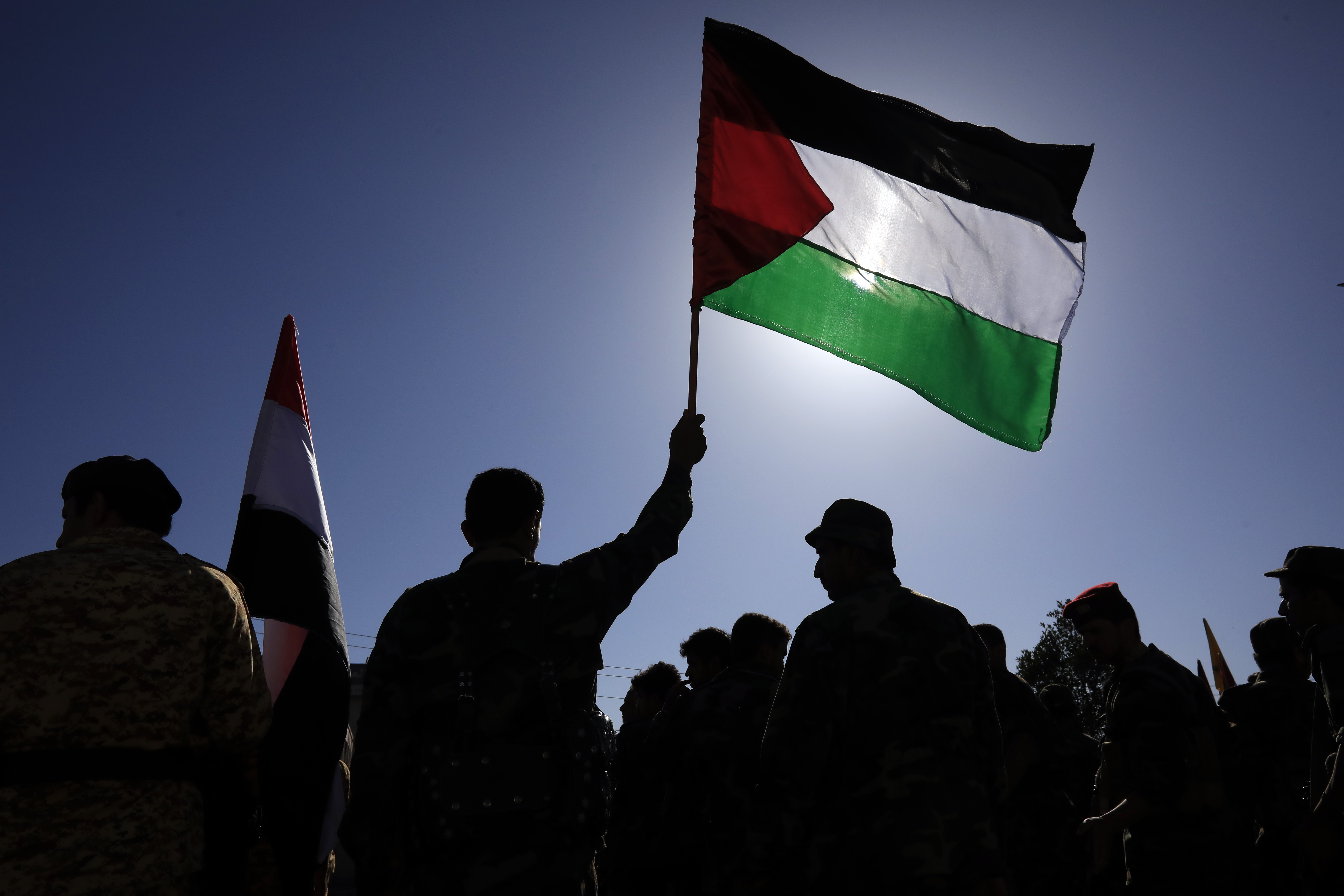 A Houthi fighter holds up a Palestinian flag during a military parade in solidarity with Palestinians in the Gaza Strip, in Sana'a, Yemen
