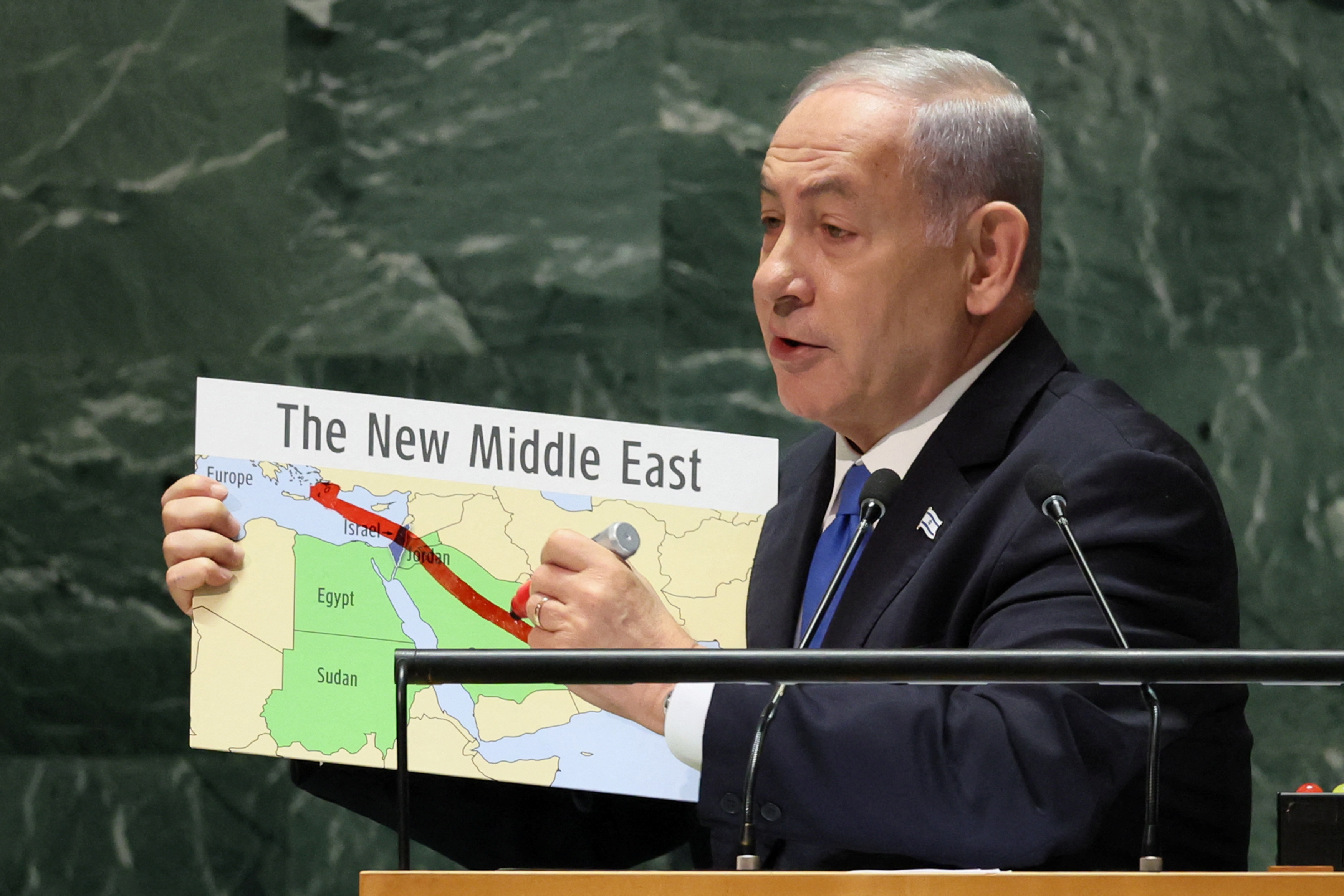 Benjamin Netanyahu holds a Middle East map with a red line on it