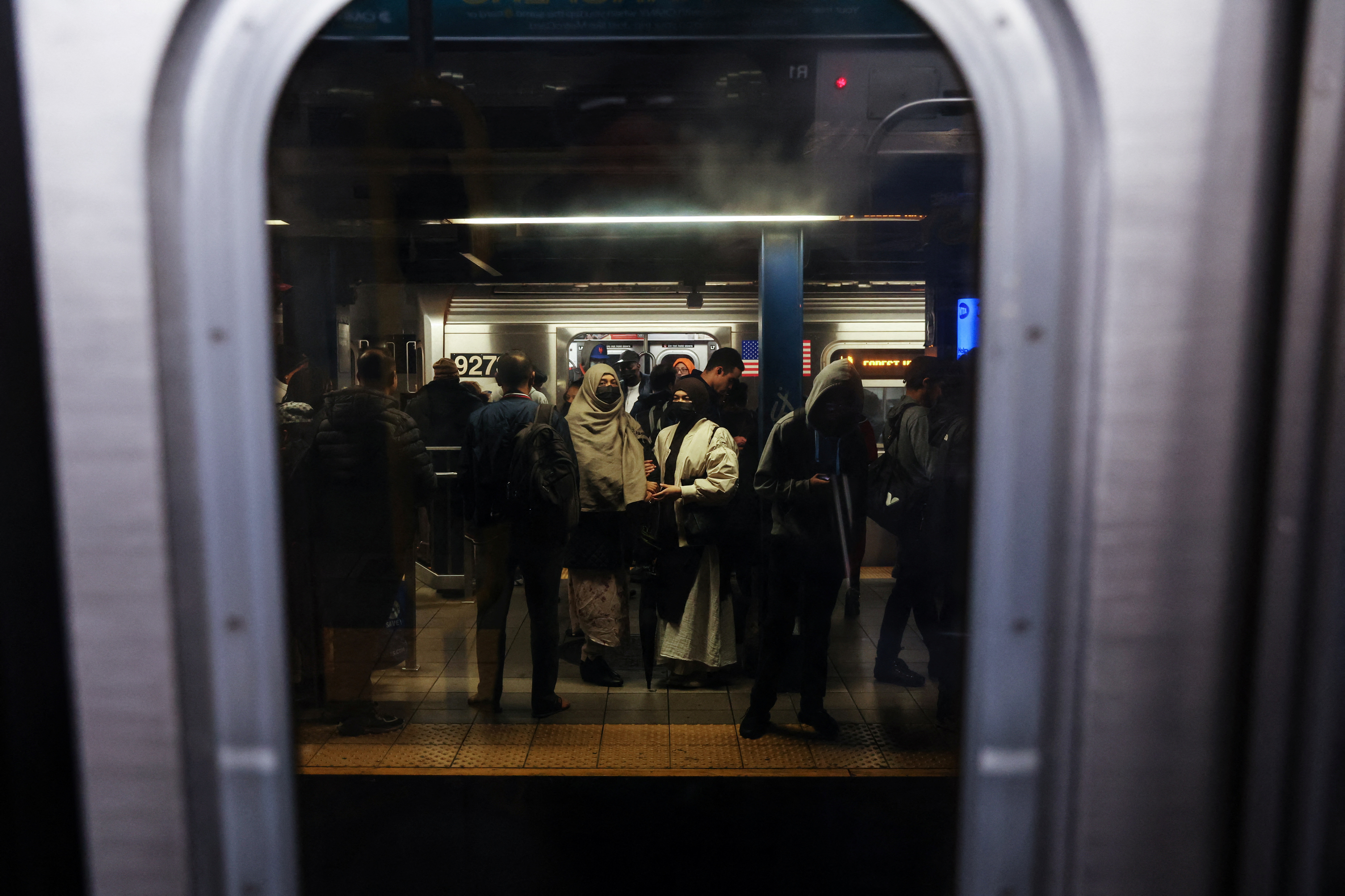 A view from the window of a subway car, looking out on to the platform.