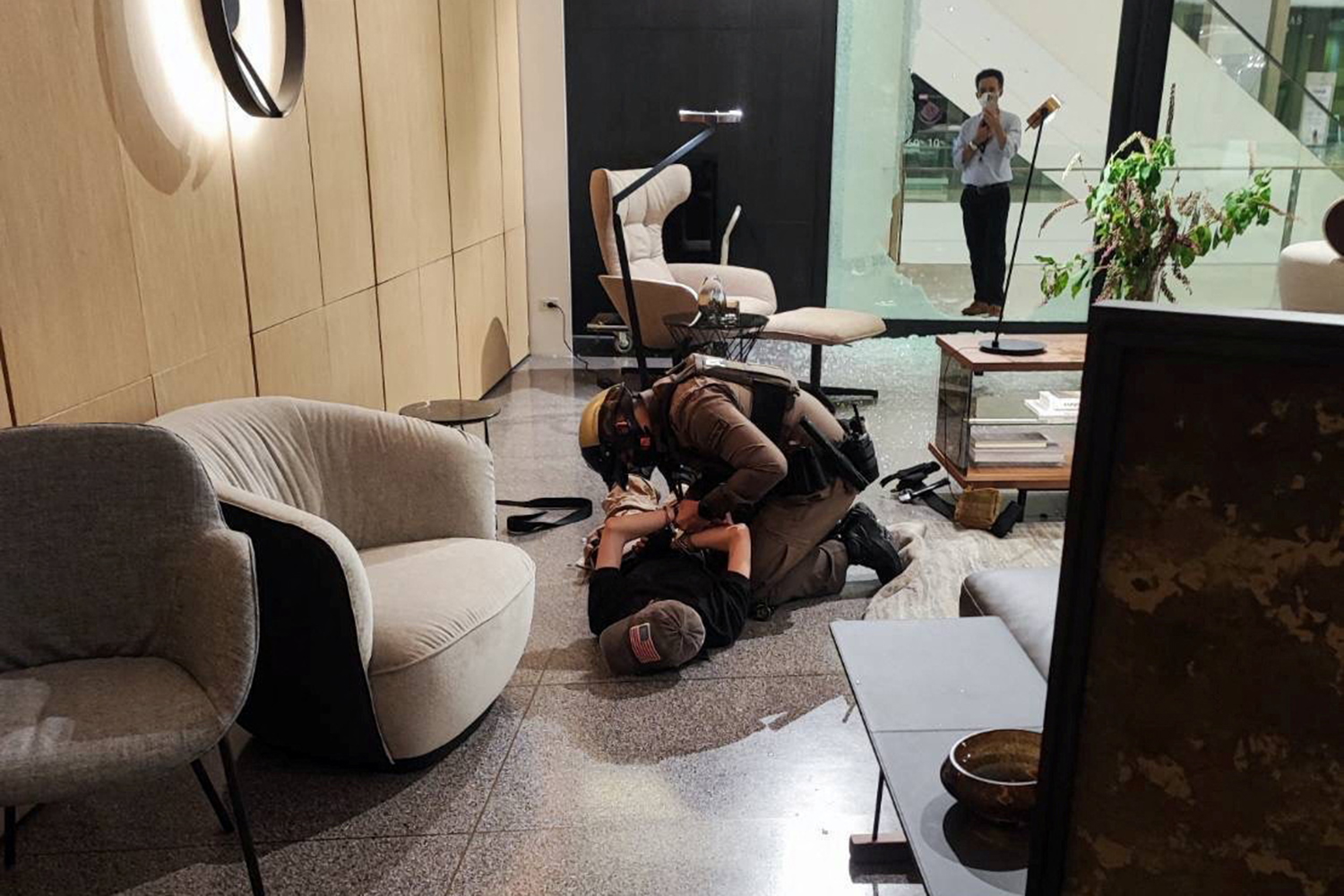 A suspected gunman is detained following shots fired at the luxury Siam Paragon shopping mall, in Bangkok