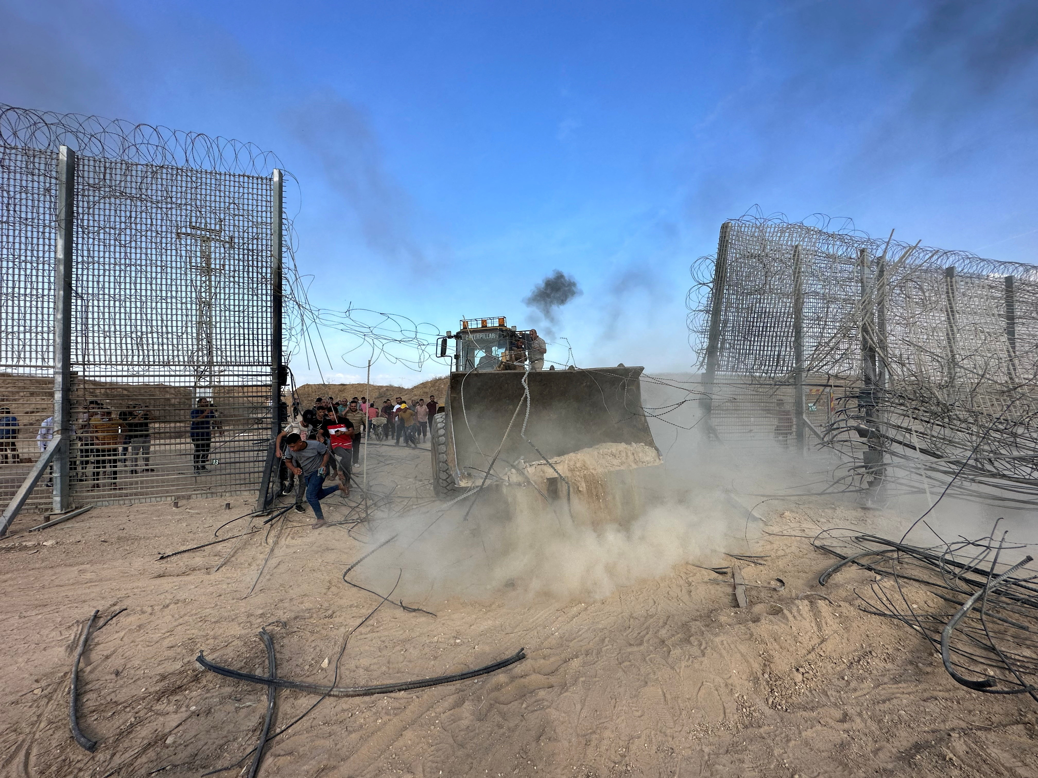 Palestinians break into the Israeli side of Israel-Gaza border fence after gunmen infiltrated areas of southern Israel