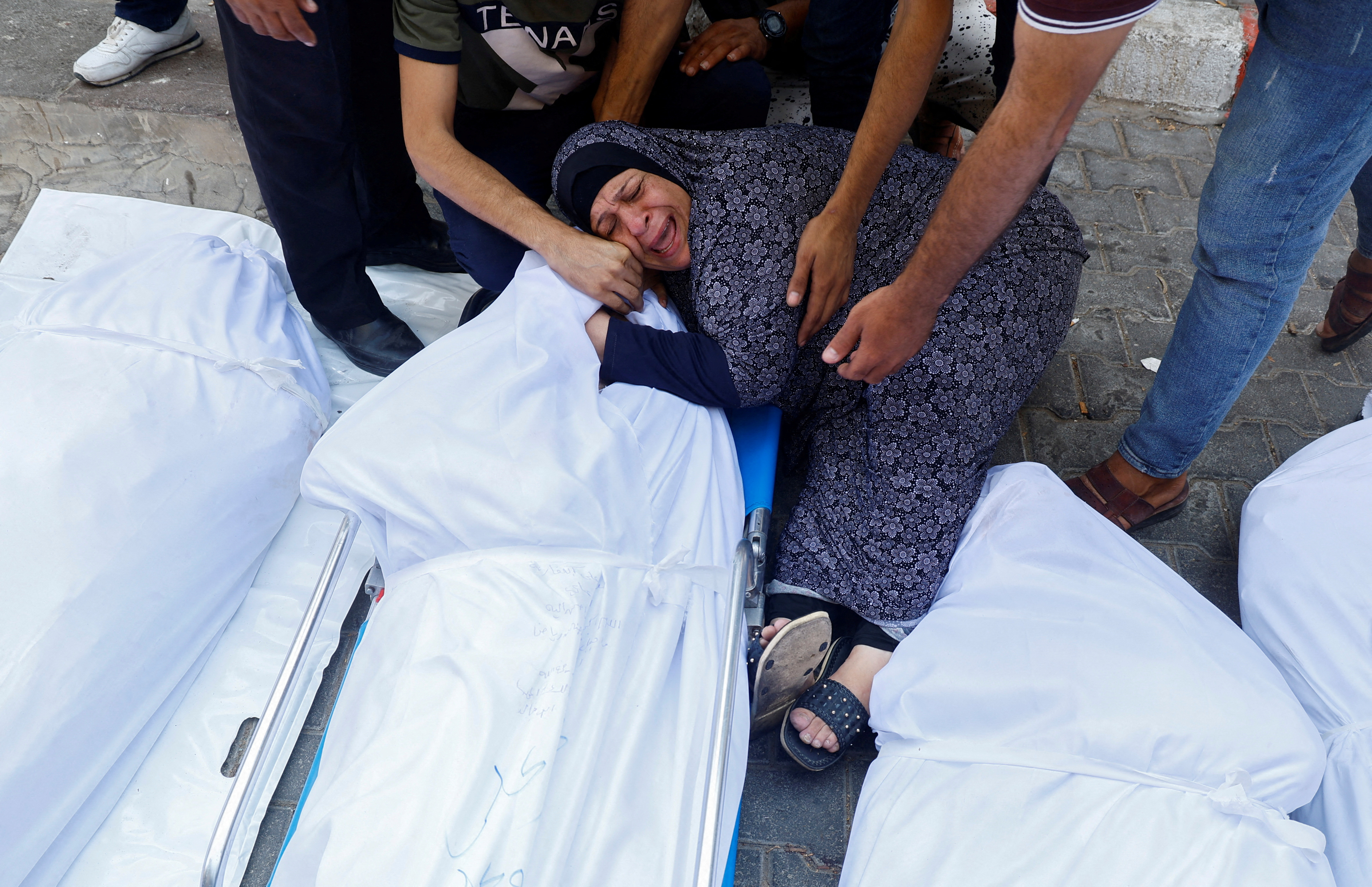A relative reacts next to the bodies of Palestinians killed in Israeli strikes, at a hospital in Gaza City
