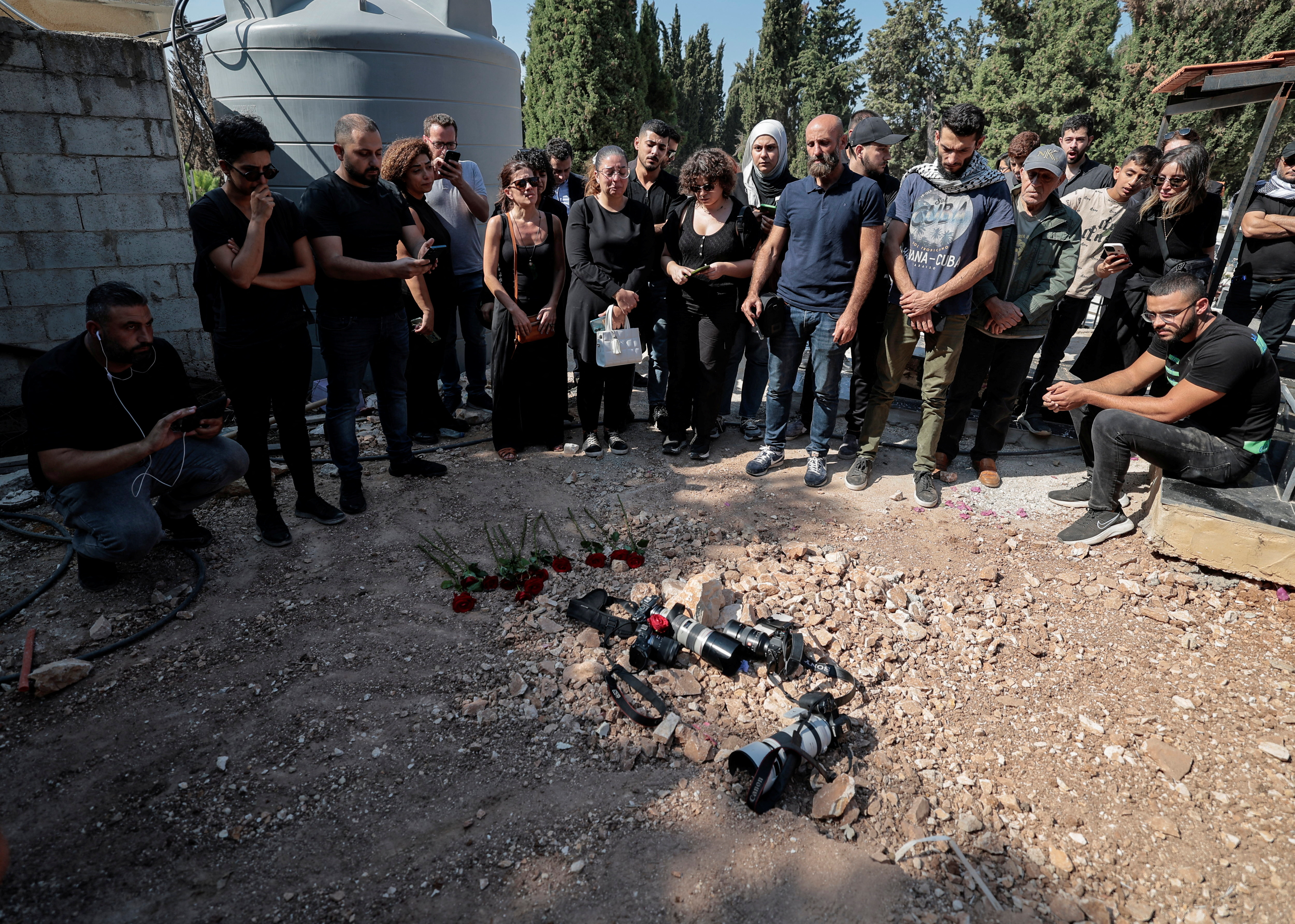 Journalists put their cameras on the grave of Issam Abdallah, a Lebanese national and Reuters videojournalist who was killed in southern Lebanon by shelling from the direction of Israel, to pay tribute to him during his funeral in his home town of Al Khiyam, Lebanon October 14, 2023