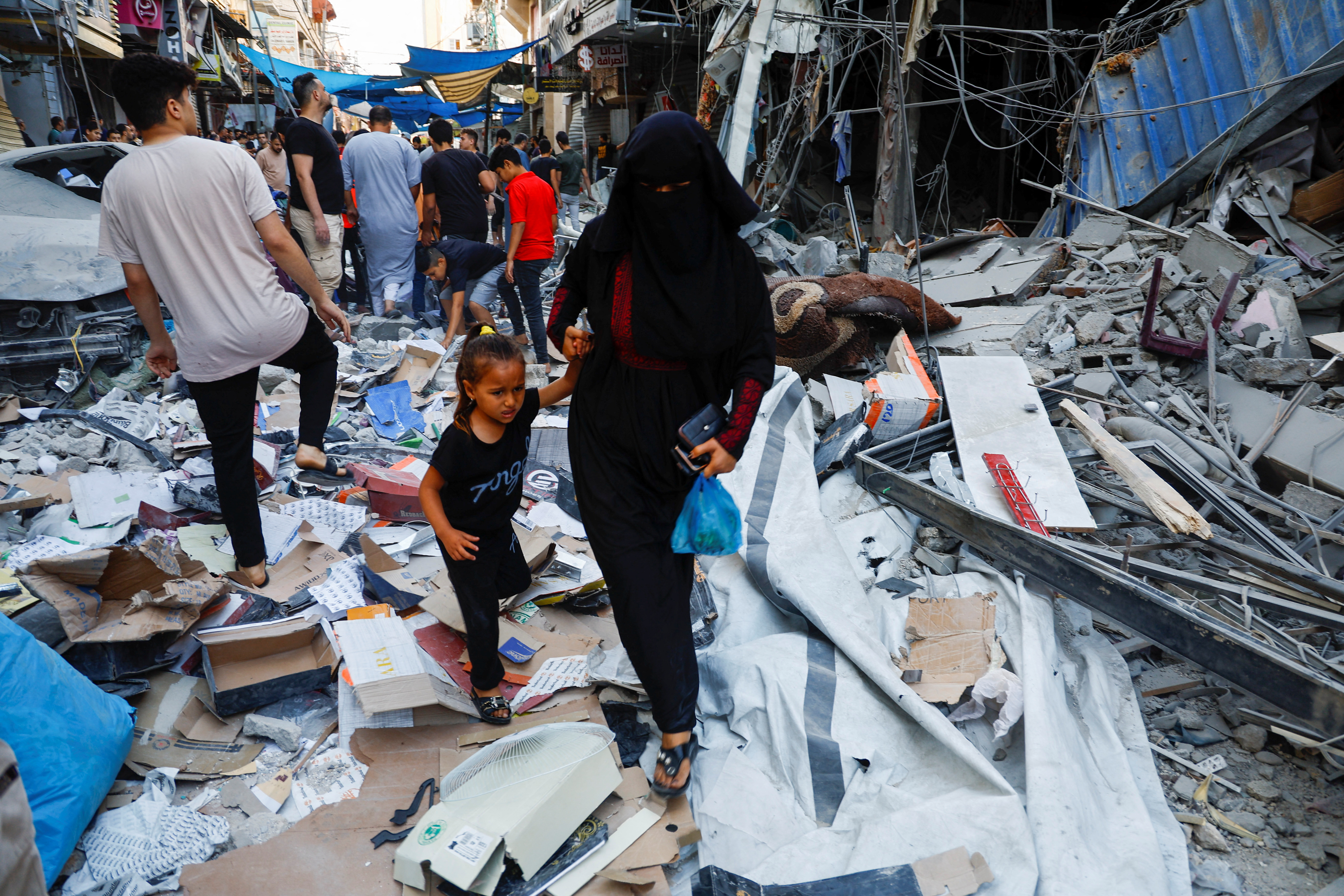 palestinans walking in rubble
