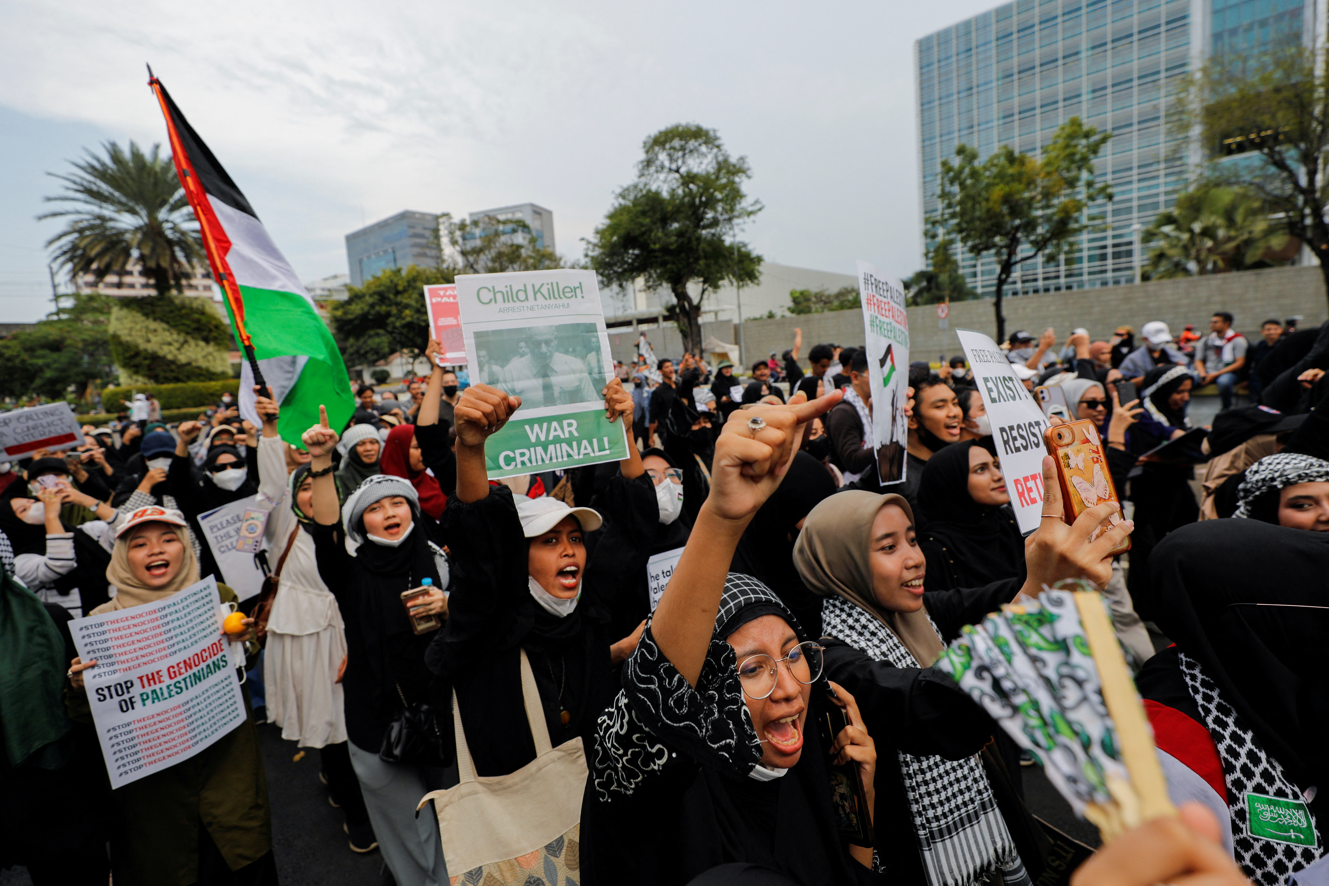 Pro-Palestinian supporters carrying placards shout slogans while taking part in a rally