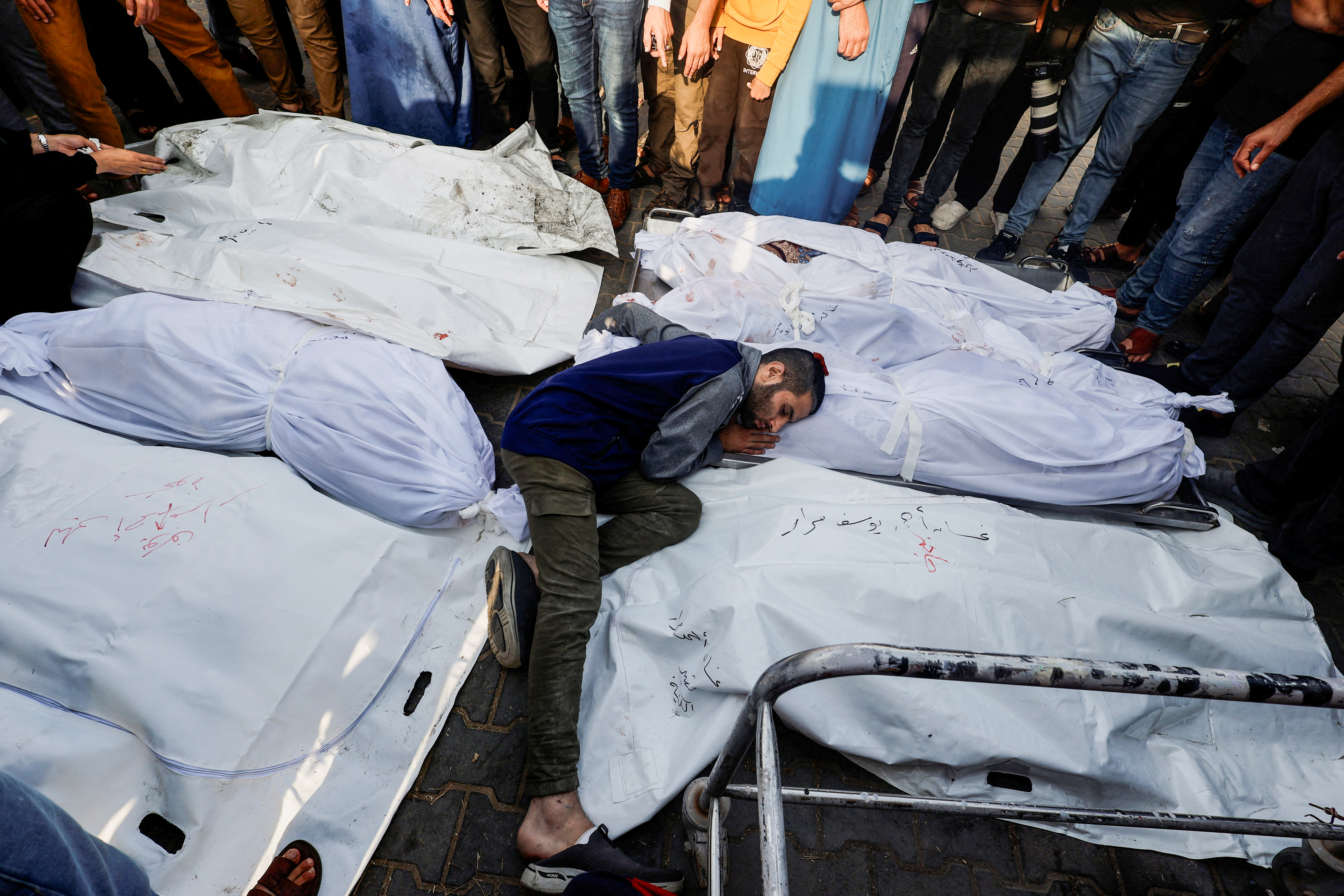 A mourner reacts amidst the bodies as people attend a funeral of Palestinians killed in Israeli strikes