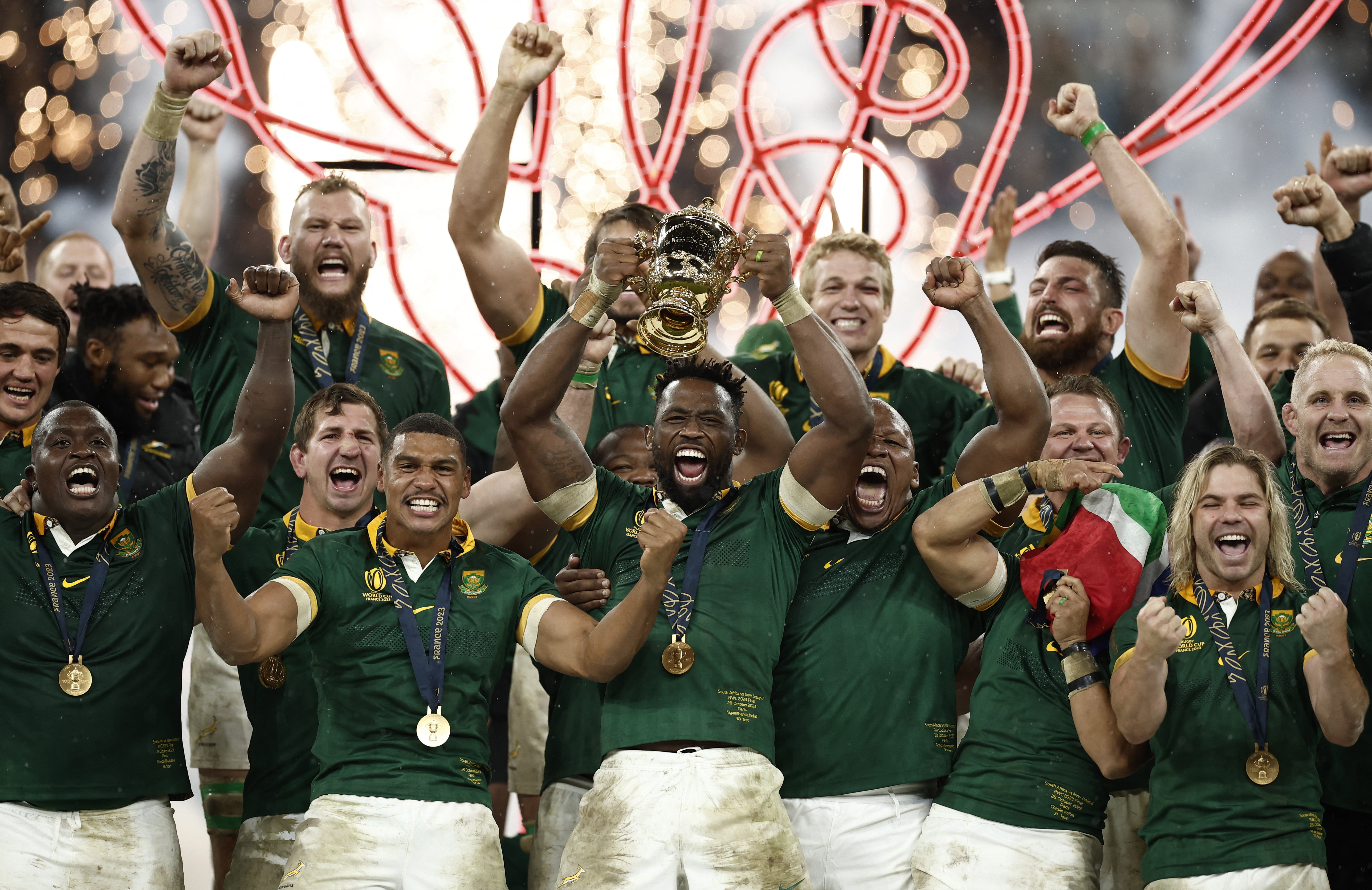 South Africa's Siya Kolisi lifts The Webb Ellis Cup surrounded by cheering teammates