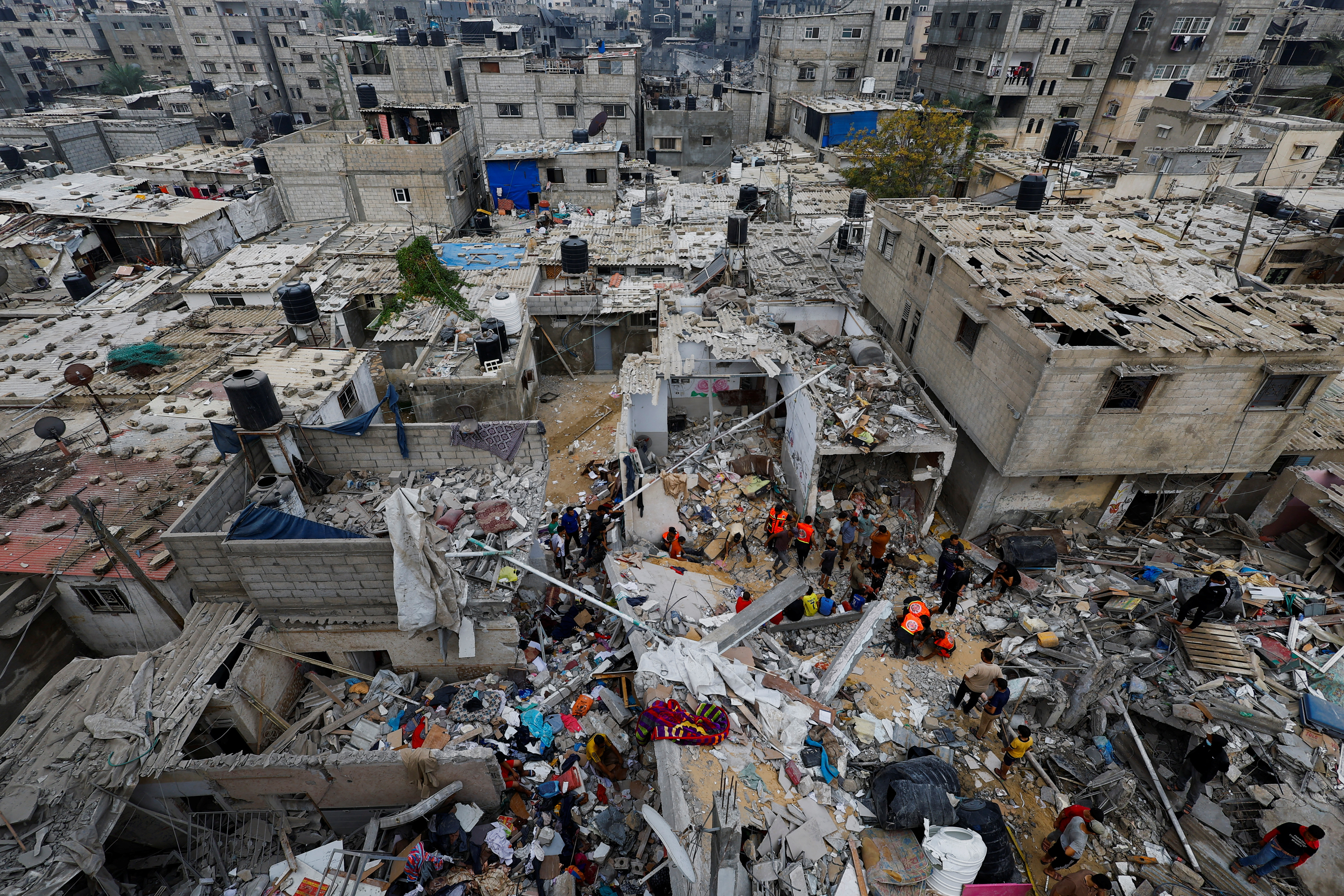 Emergency personnel and people check the damage at the site of Israeli strikes on houses, amid the ongoing conflict between Israel and Palestinian Islamist group Hamas, in Khan Younis in the southern Gaza Strip
