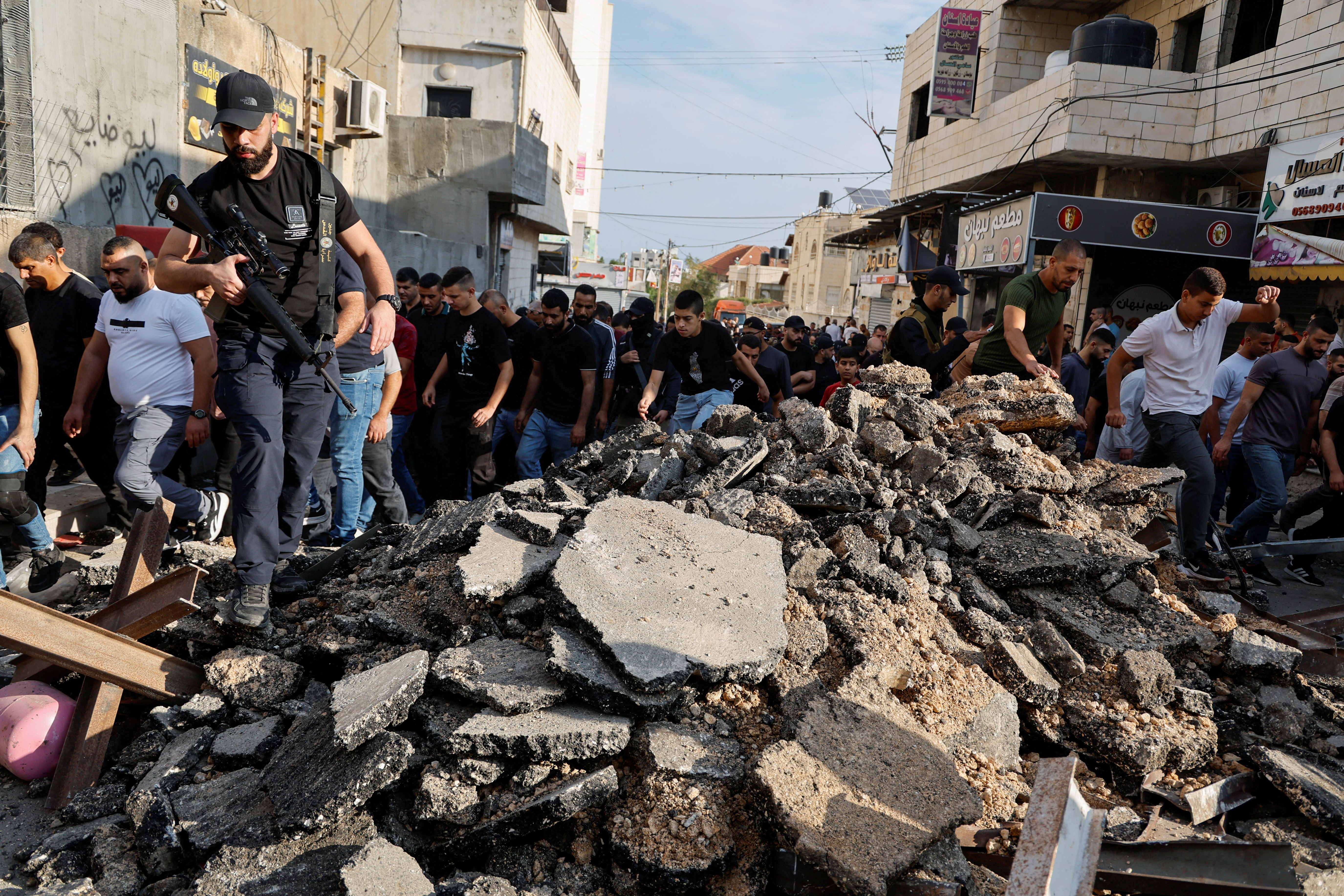 Mourners walk as they carry bodies of Palestinians (not pictured), who were killed in an Israeli raid at the Jenin