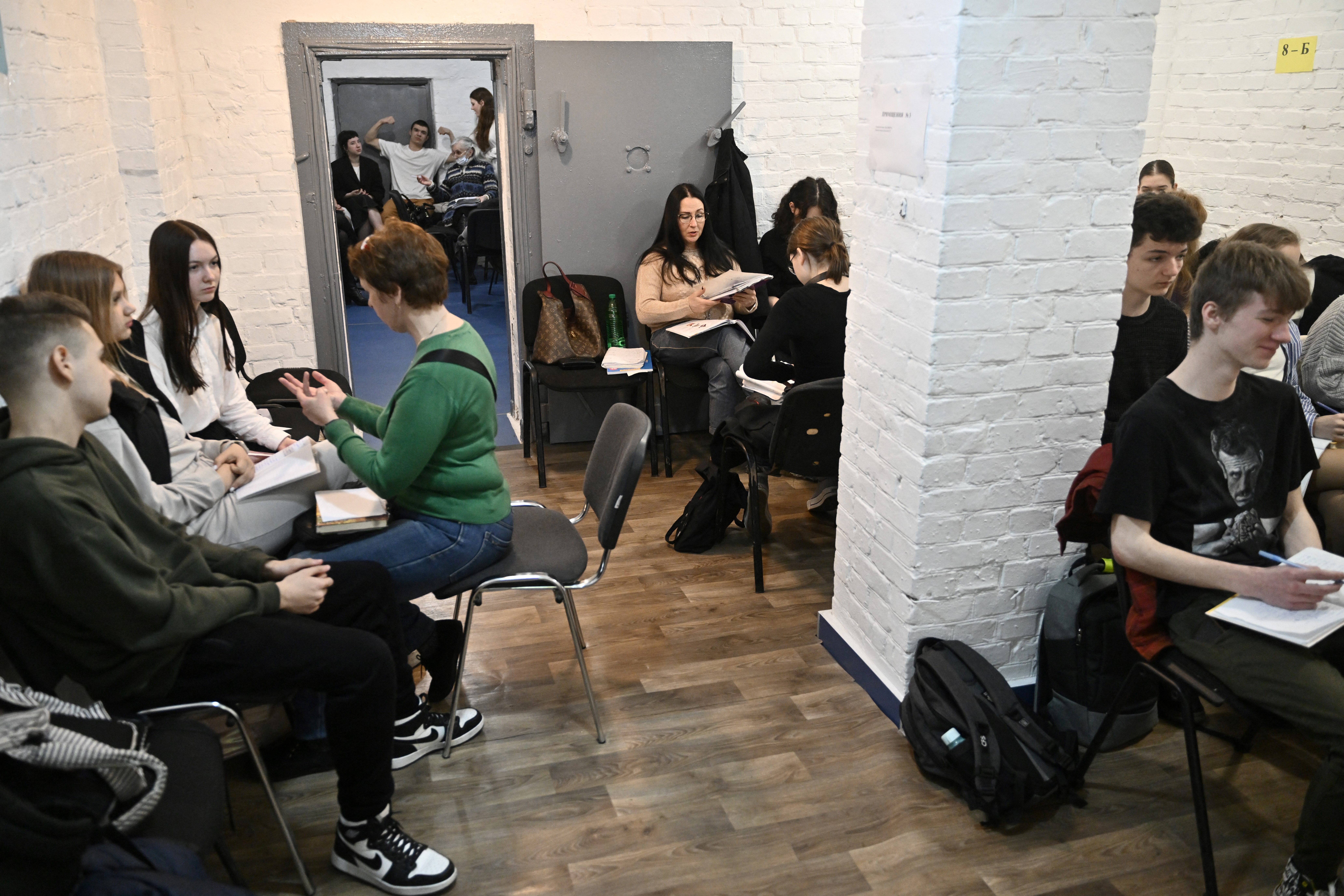 Children study in an air-raid shelter in the cellar of a school after an alarm signal in Kyiv on March 23, 2023, amid the Russian invasion of Ukraine. In the cellar of a Kyiv kindergarten decorated with bunting and wall paintings of doughnuts and cats, dozens of children are taking shelter during an air raid. The staff try to reduce the psychological impact on children who can barely remember a time without sirens and fear. (Photo by Genya SAVILOV / AFP)