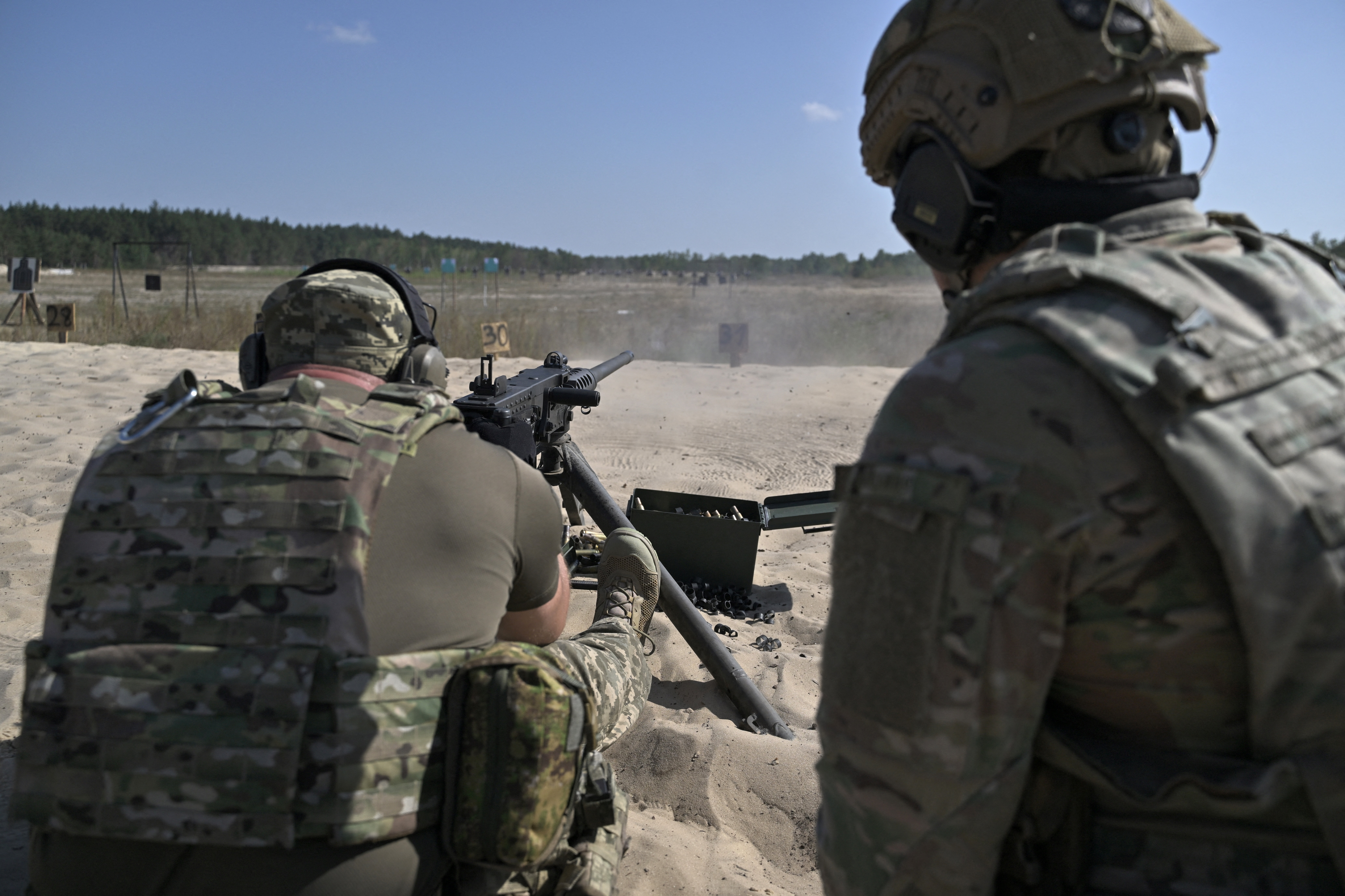 A Ukrainian servicemember fires a machine gun