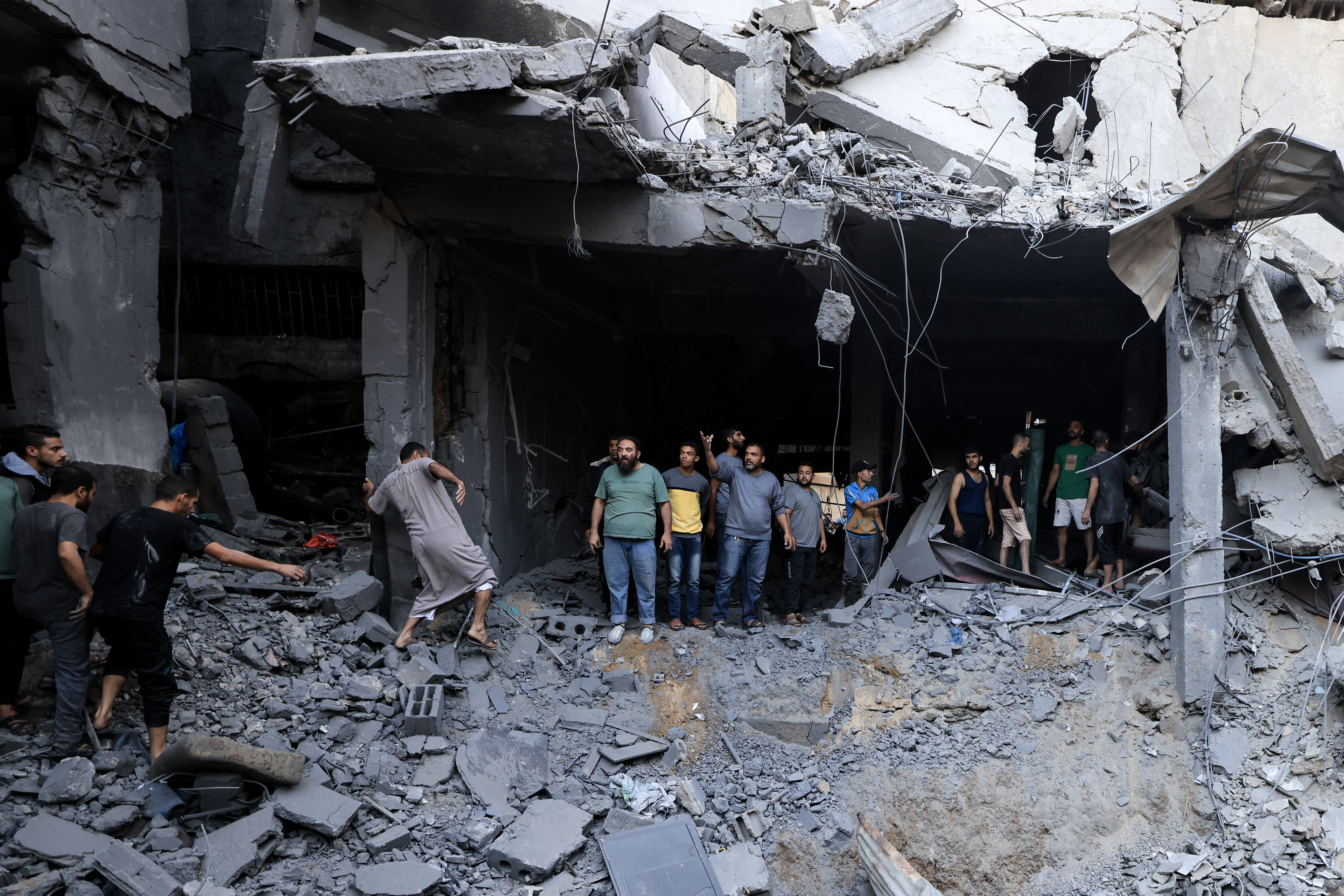 Palestinians civil look for survivors in the rubble of a building hit during Israeli bombardment in Khan Yunis