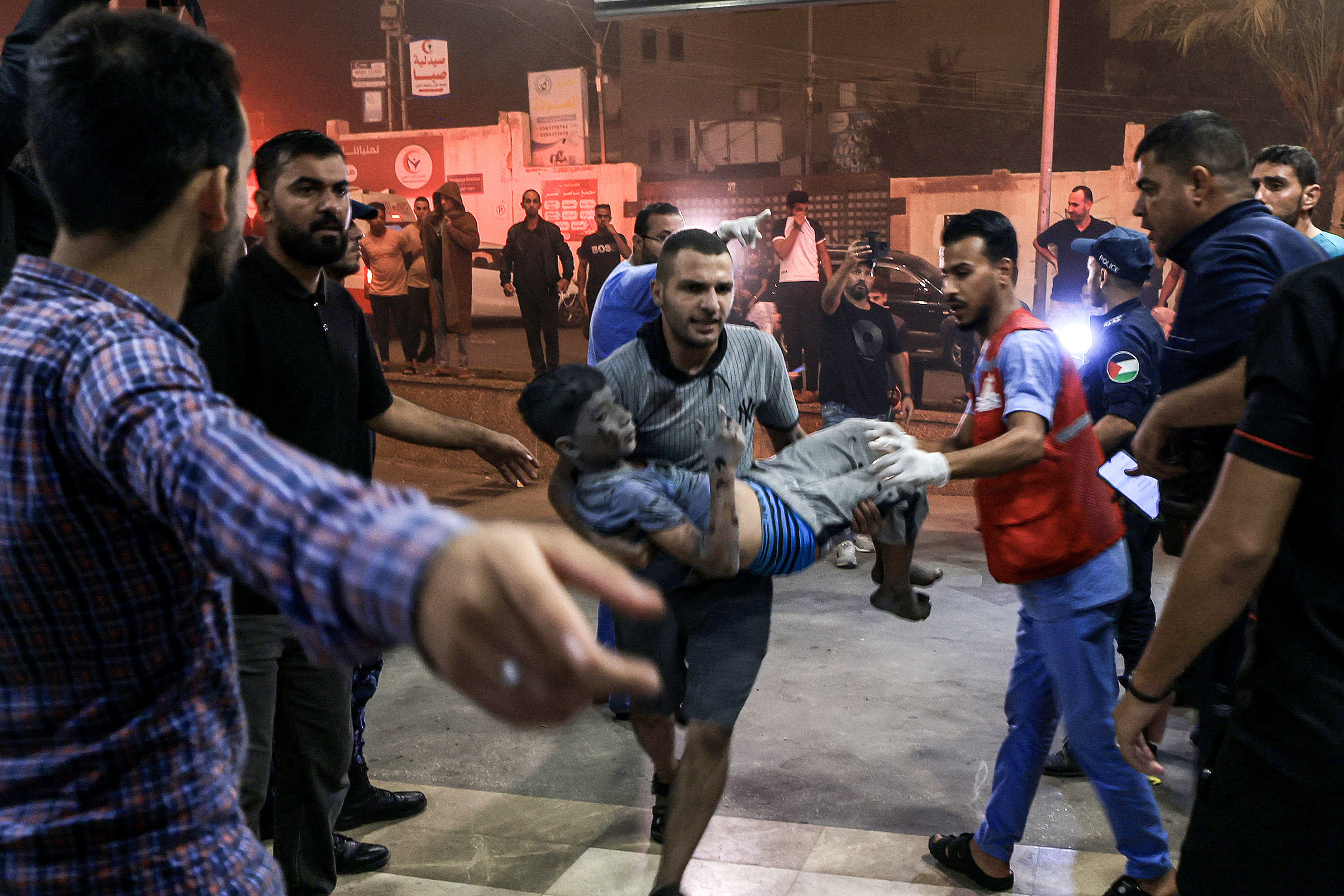 A child who was injured in Israeli bombardment is carried to the entrance for emergency treatment at Nasser hospital in Khan Yunis