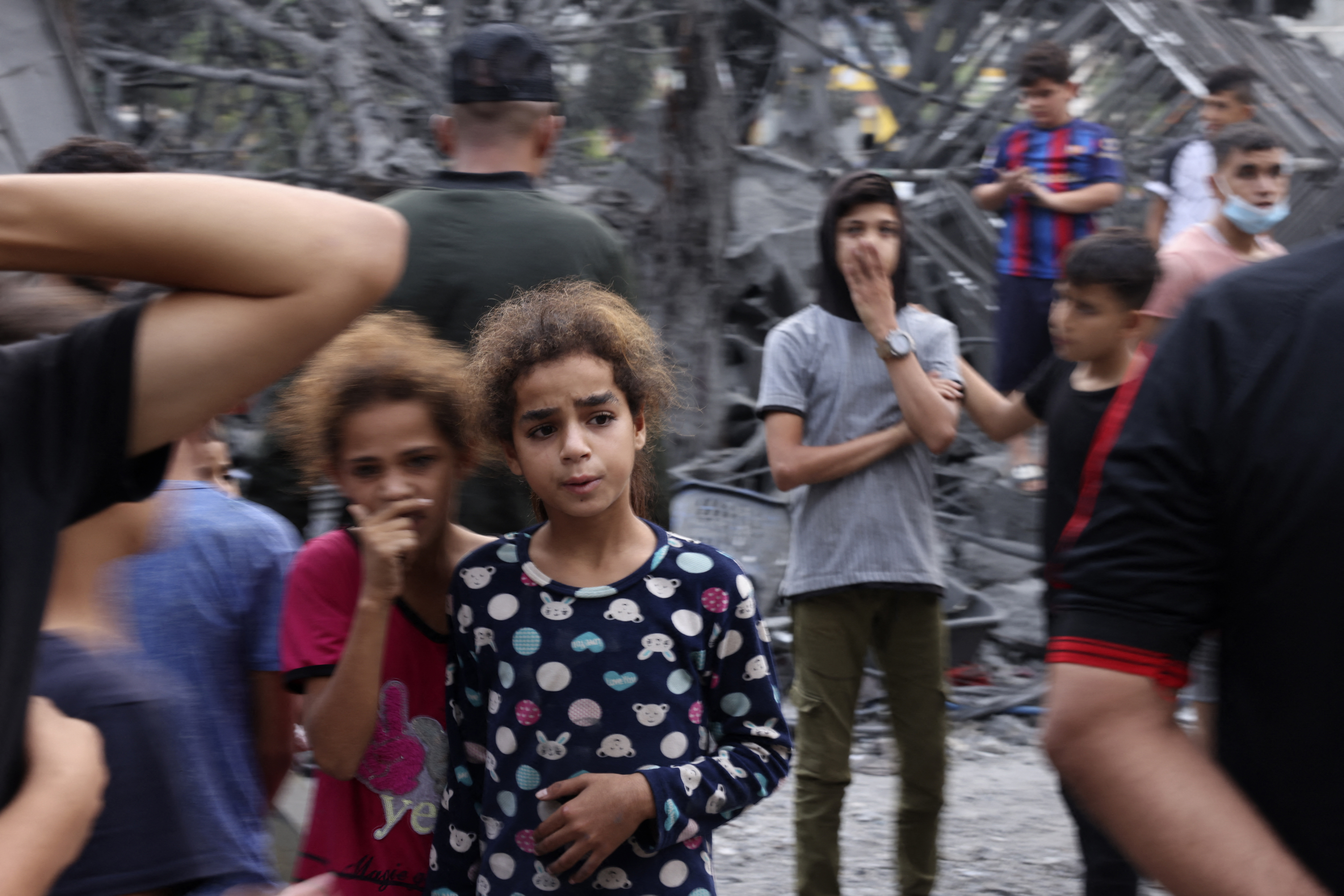 Palestinians gather near the rubble of a building following overnight Israeli strikes on the Rafah