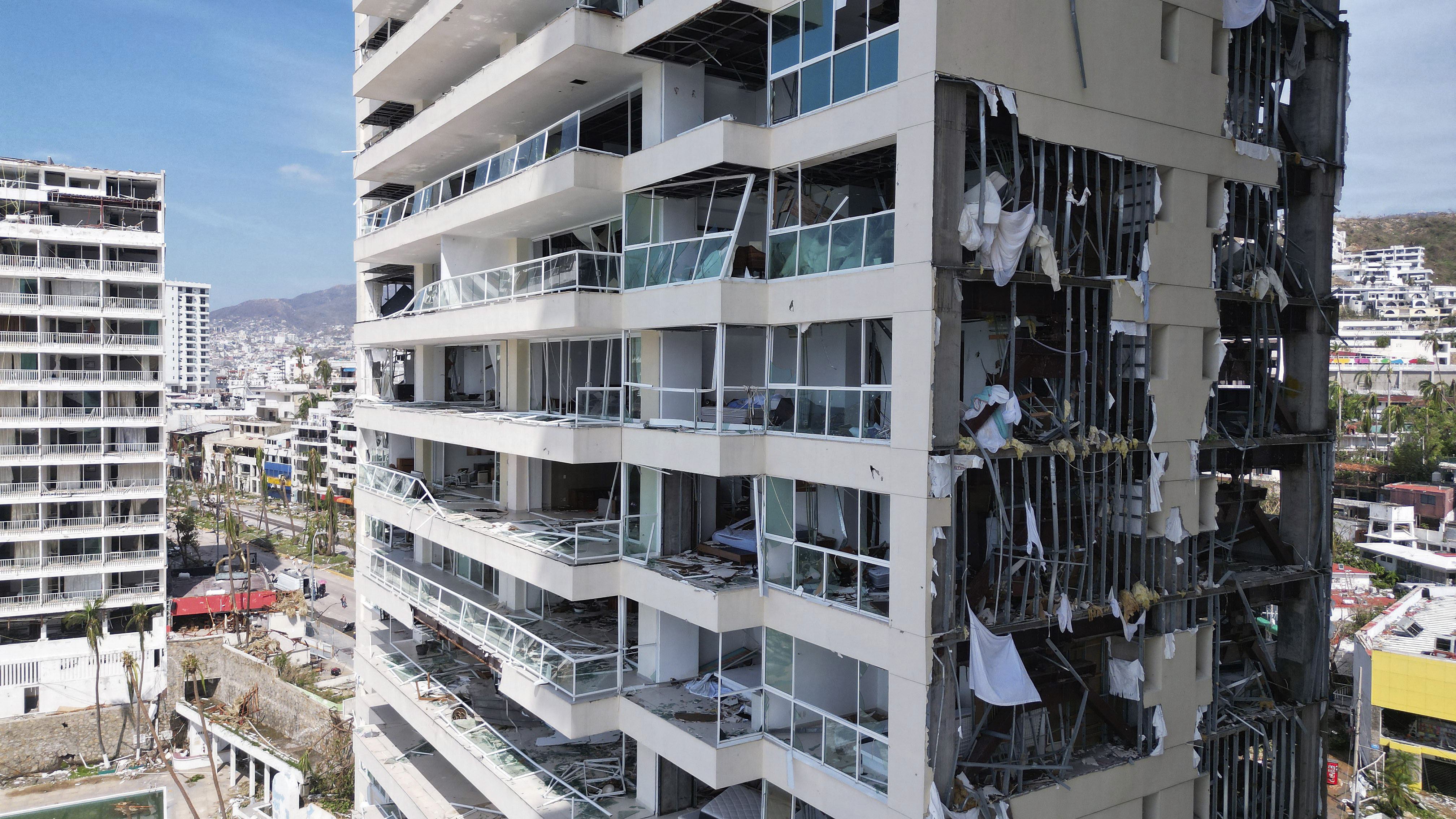 a high rise building with broken windows and chunks missing fron its facade