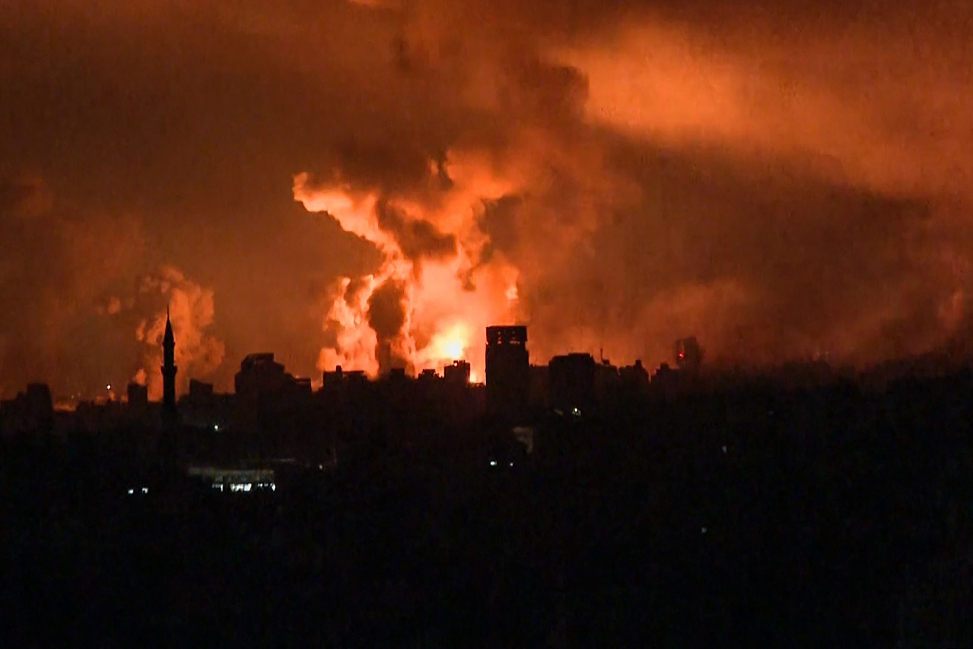 balls of fire and smoke rising above Gaza City during an Israeli strik