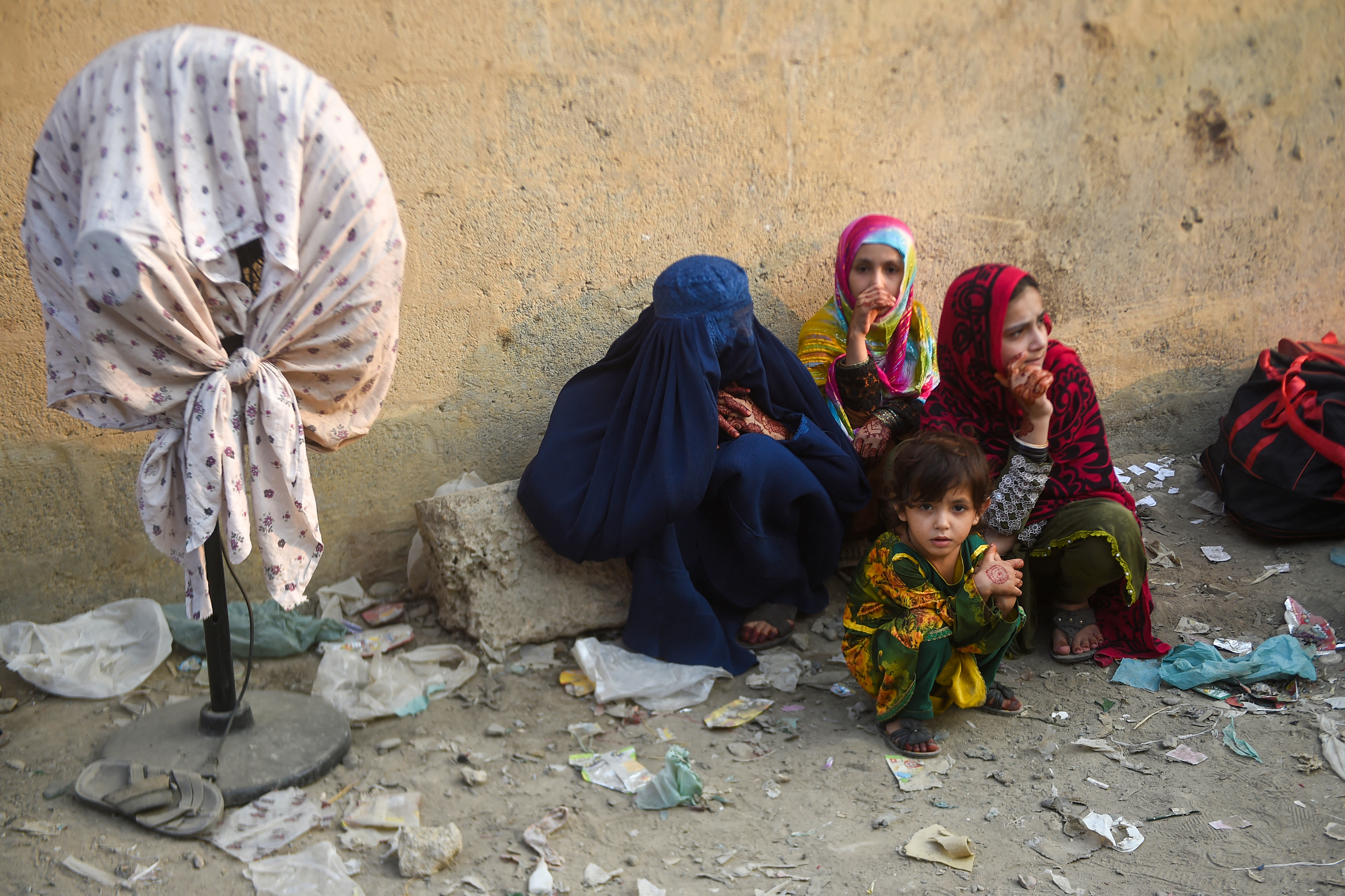 Afghan refugees wait at the Karachi bus terminal in Sindh province, to depart for Afghanistan