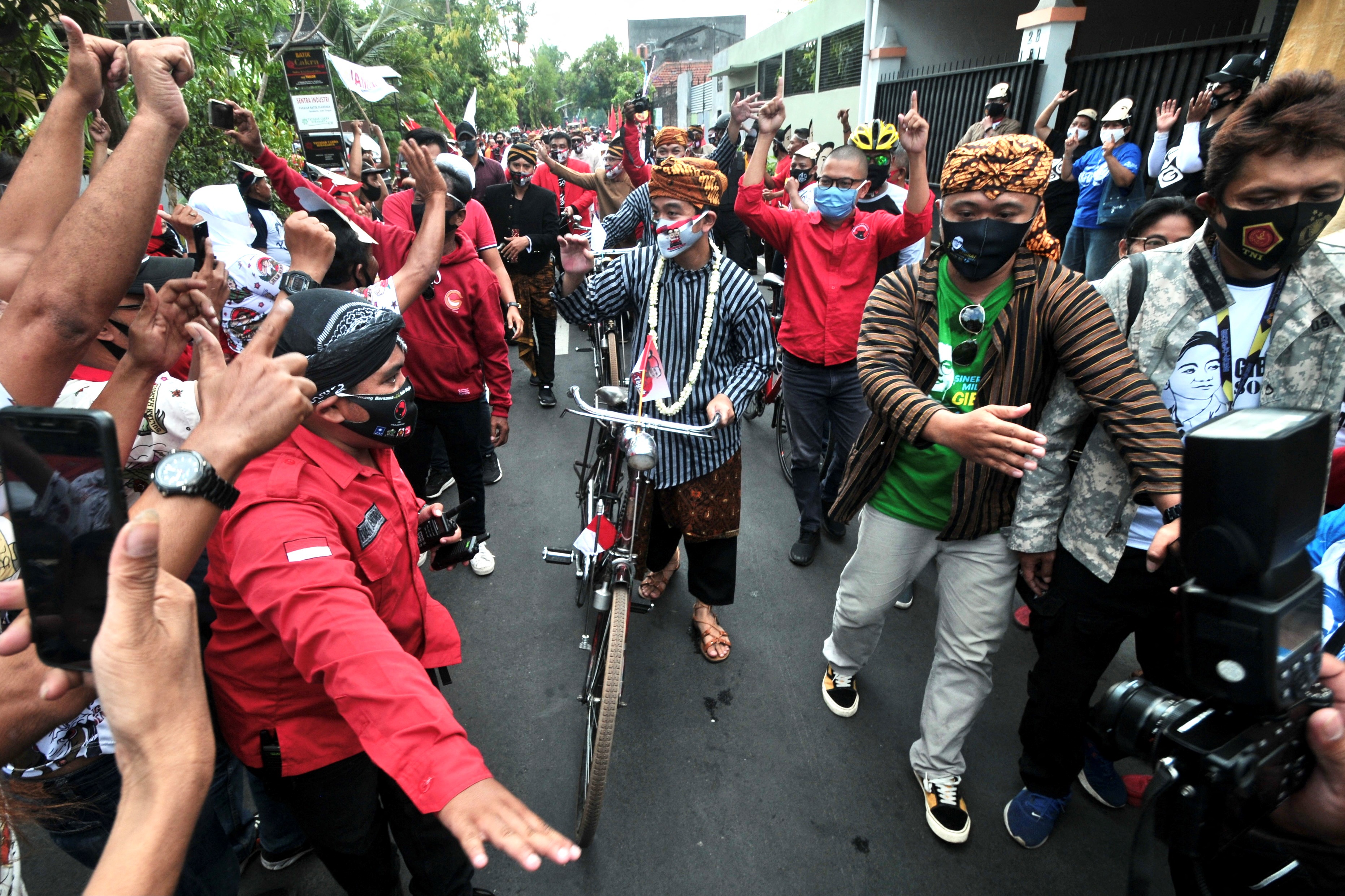 a man rides a bicycle through a crowd of people