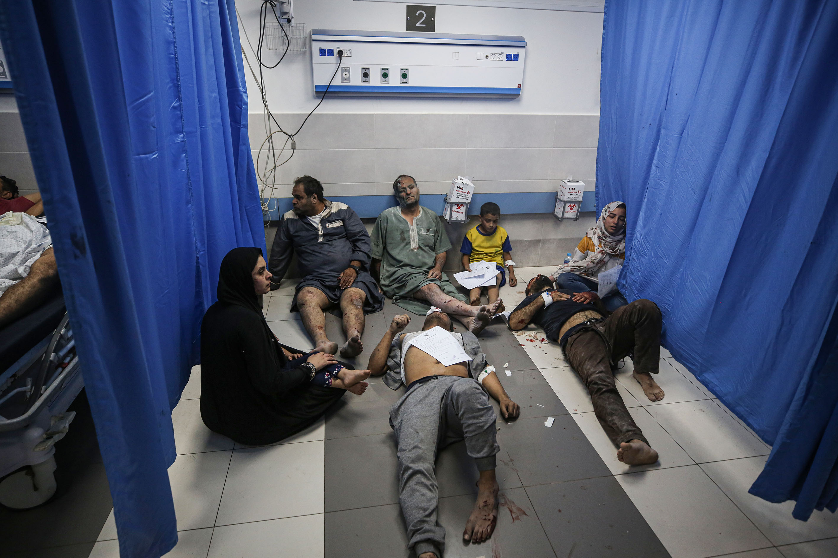 Injured people wait for medical treatment after they were brought to Al-Shifa Hospital,